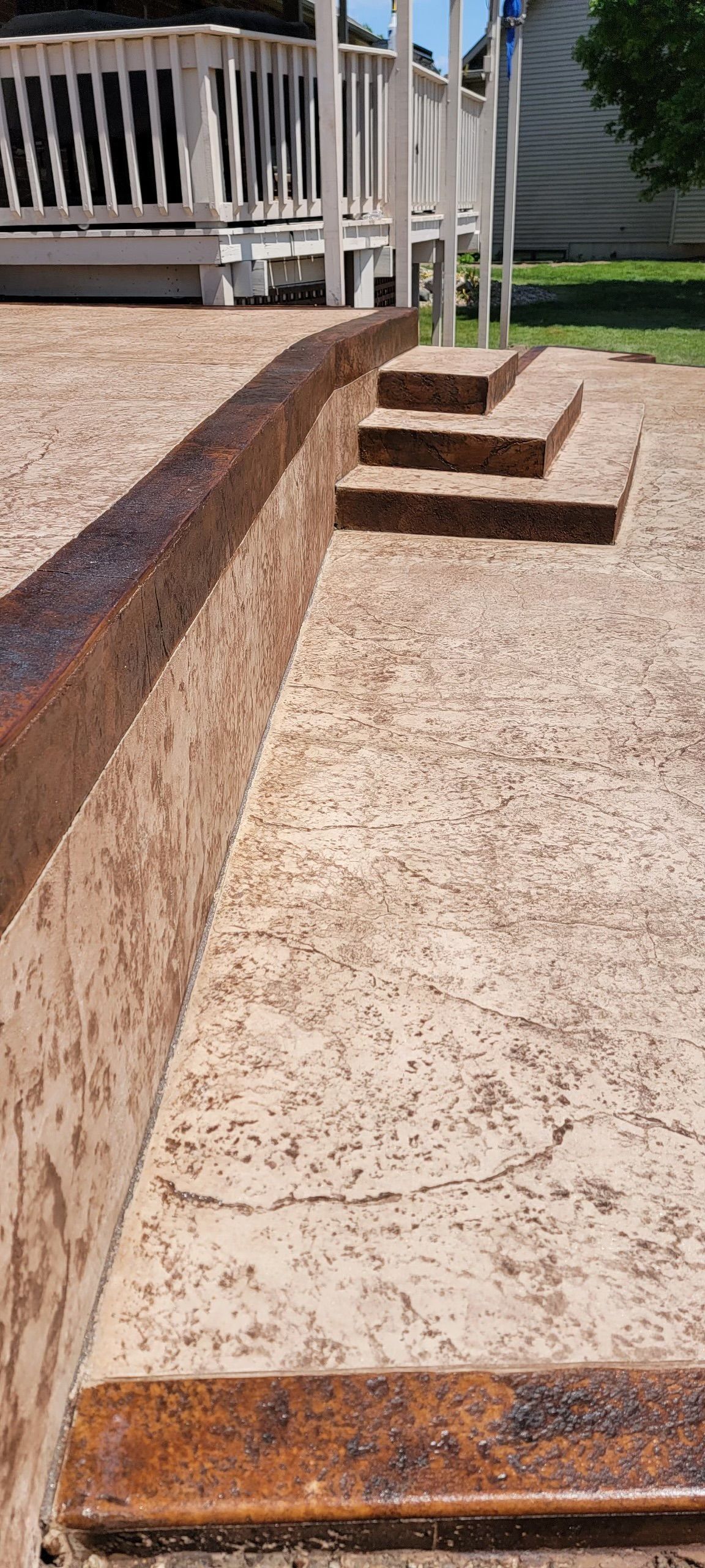 A concrete walkway with stairs leading up to a deck