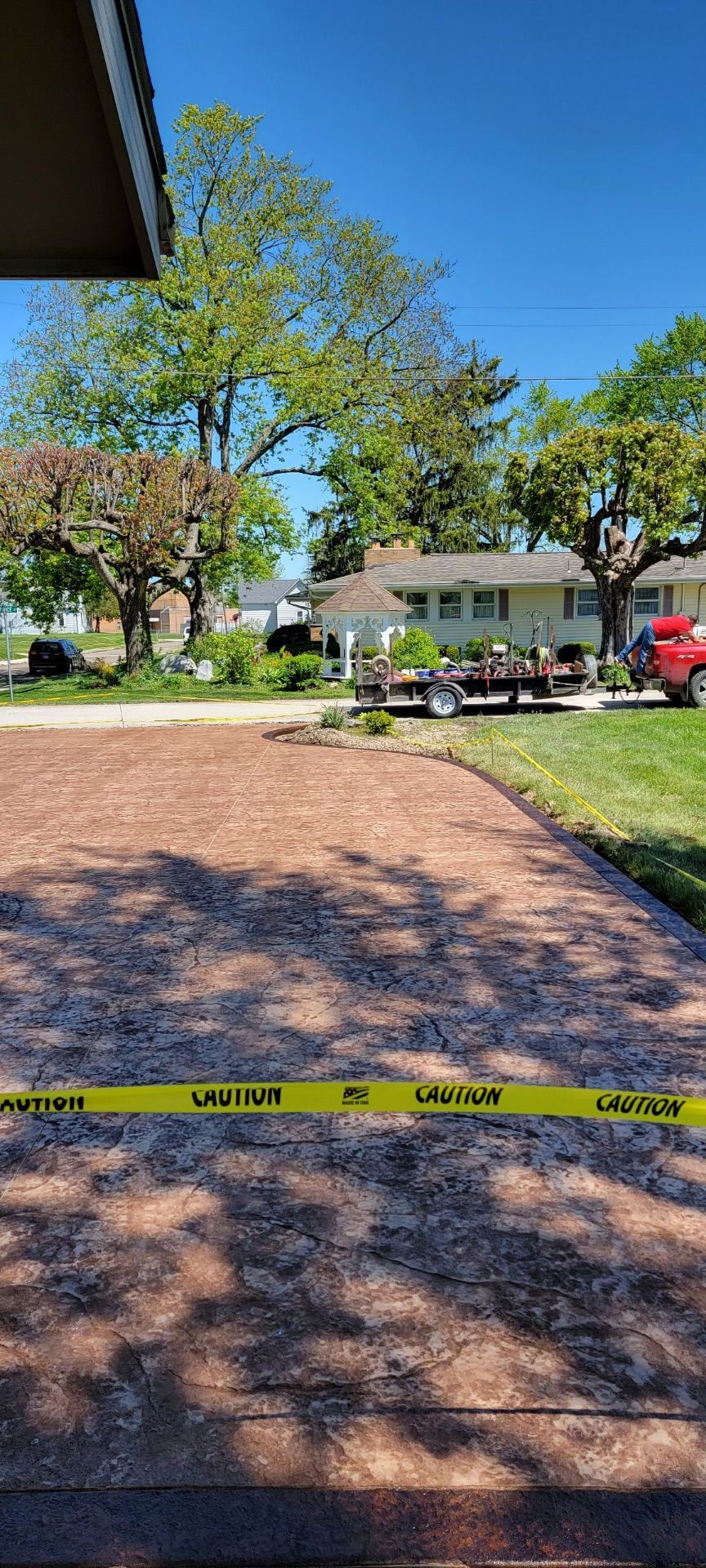 A red truck is parked in a driveway next to a house