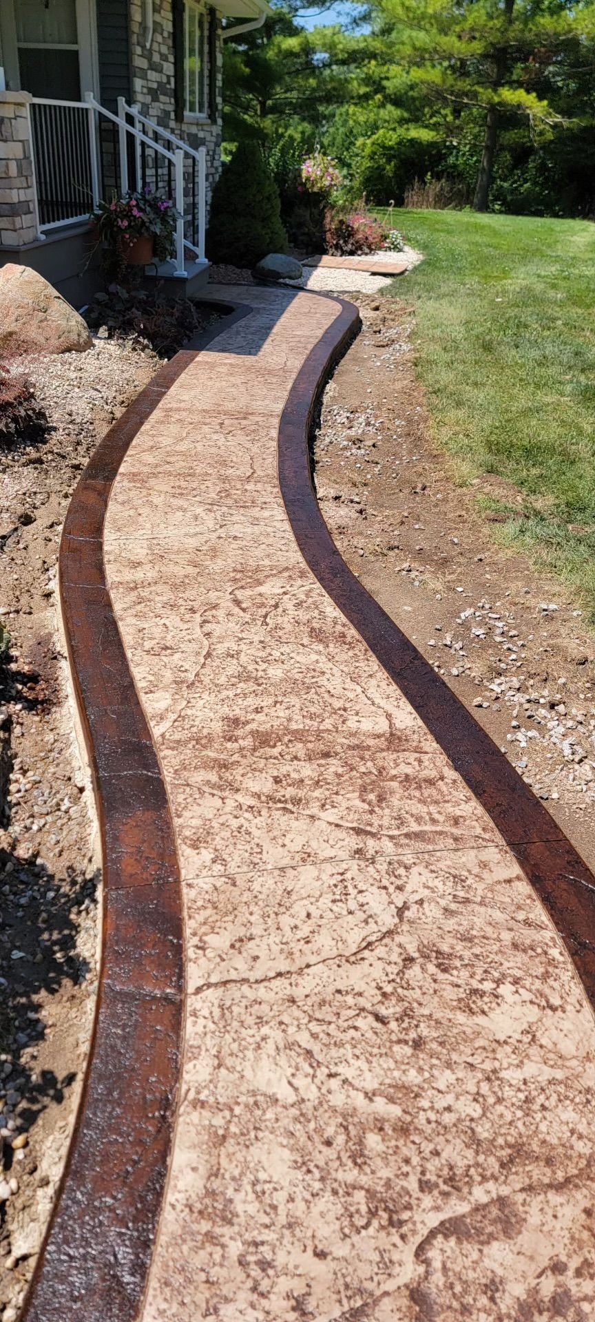 A brown concrete walkway is being built in front of a house