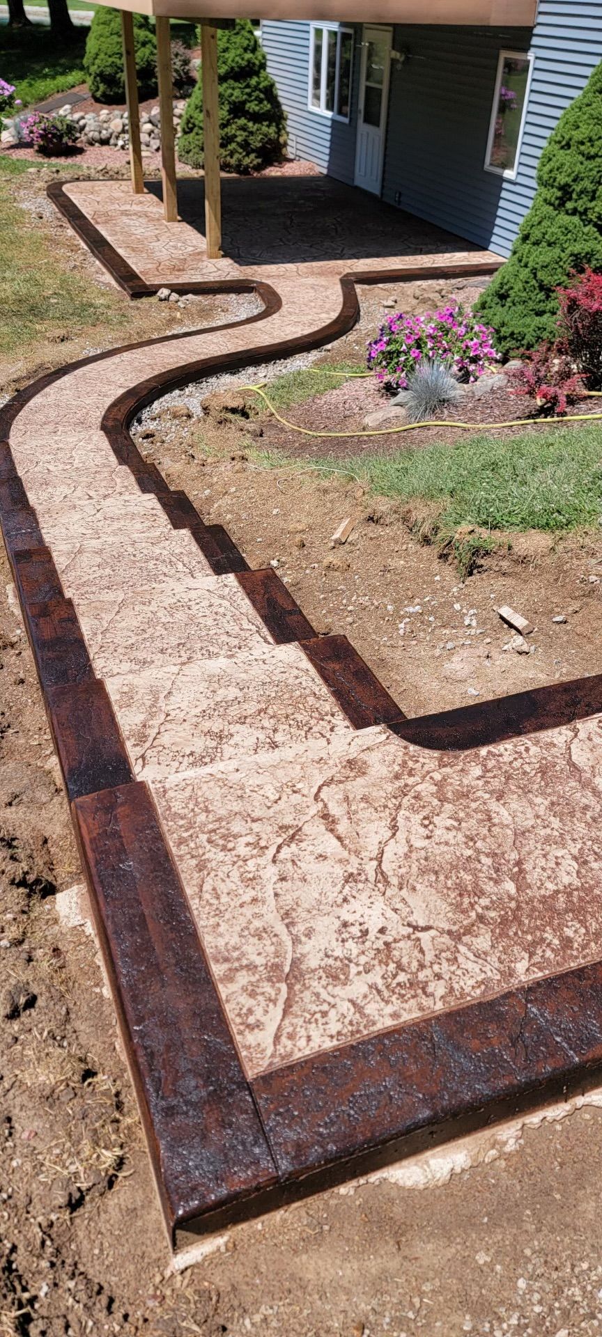 Brown concrete stairs is being built in front of a house