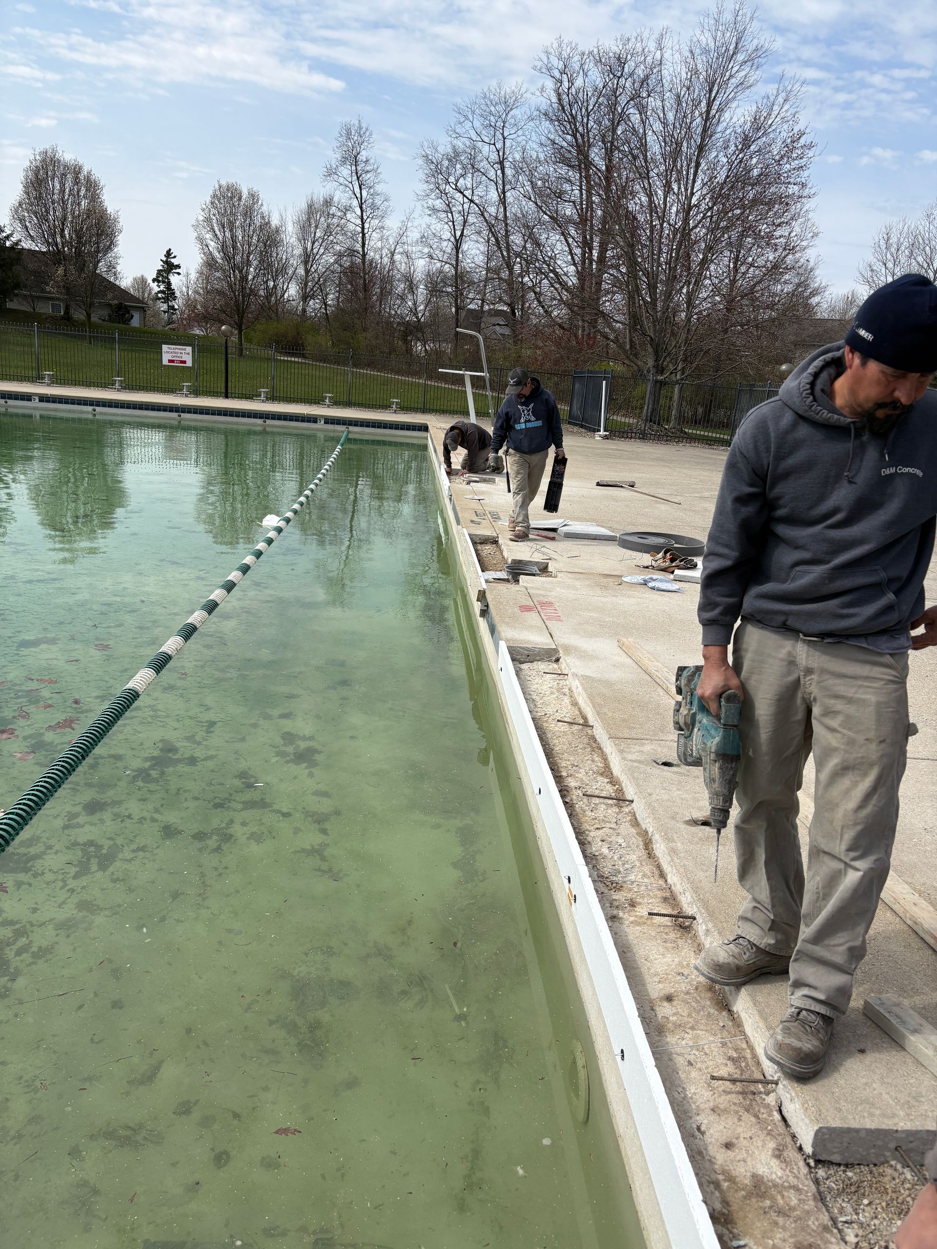 A man is standing next to a swimming pool