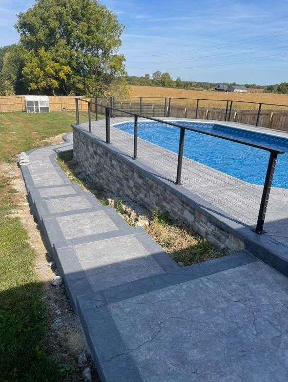 There is a swimming pool in the backyard with a walkway leading to it