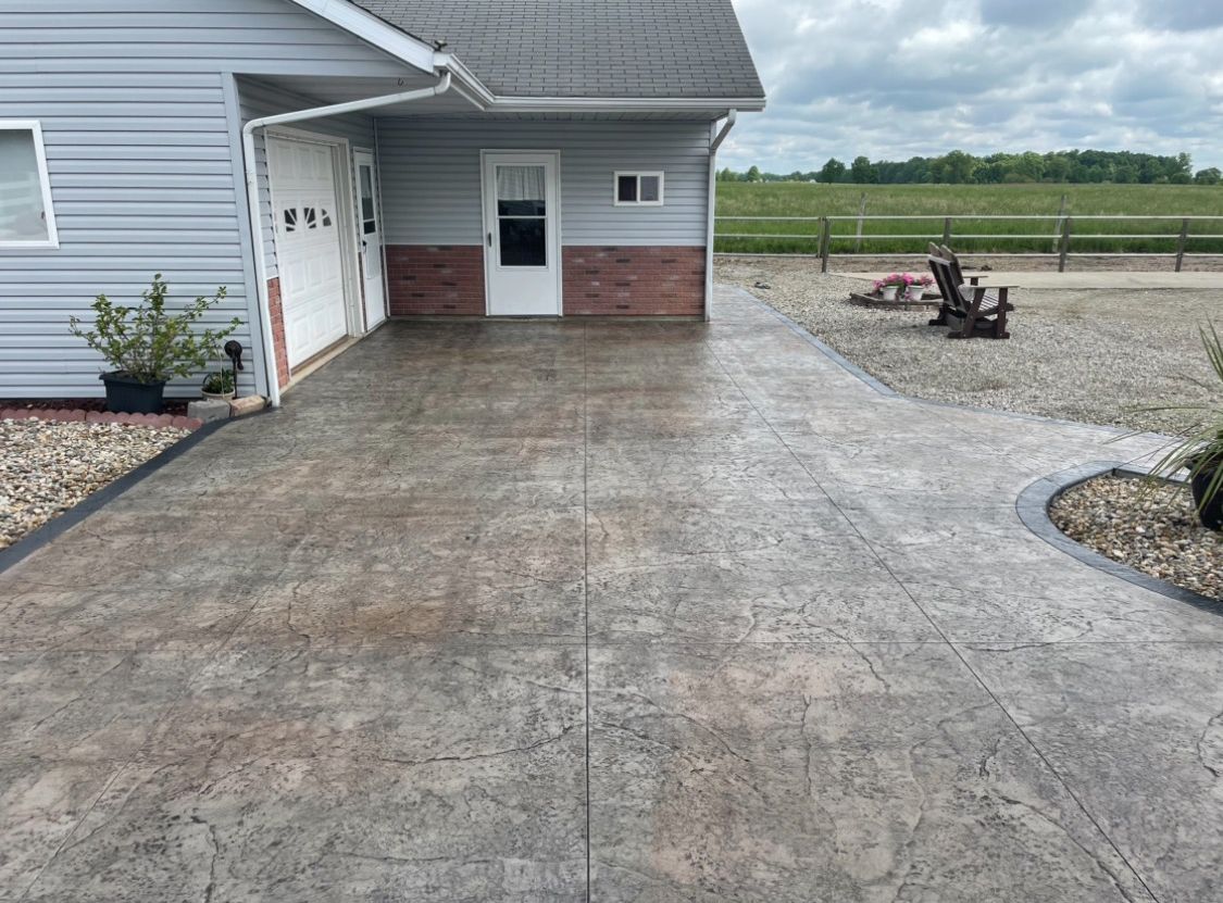 A nice concrete driveway leads to a house with a garage