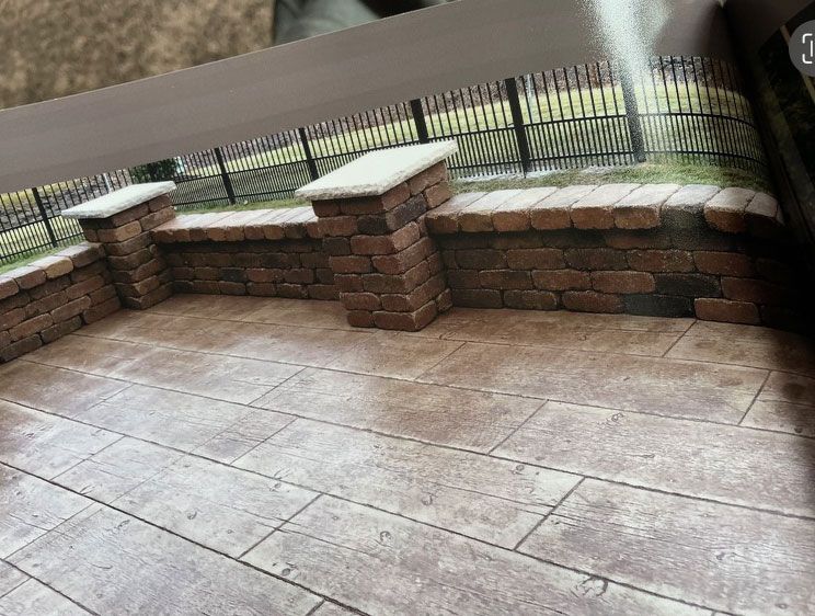 A patio with a brick wall and a fence in the background