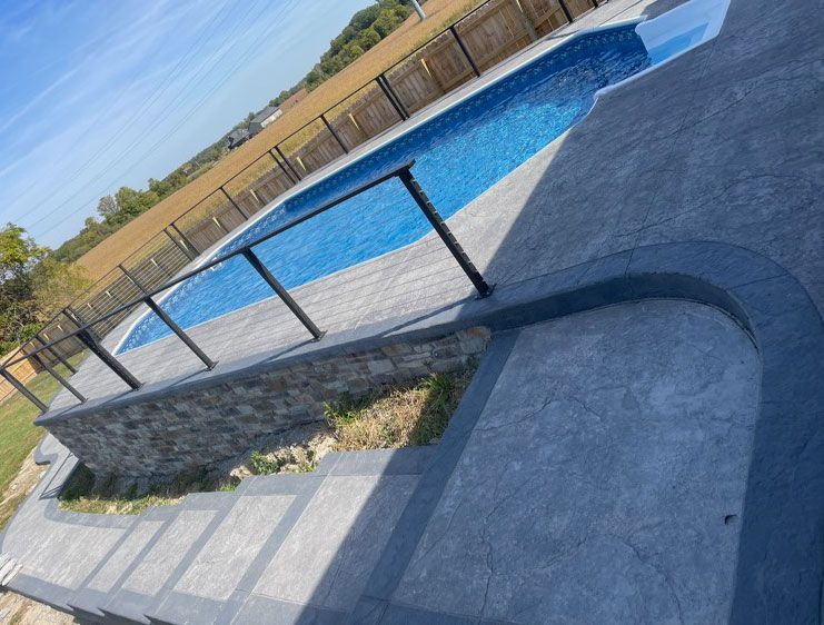 A swimming pool with a fence around it and stairs leading to it