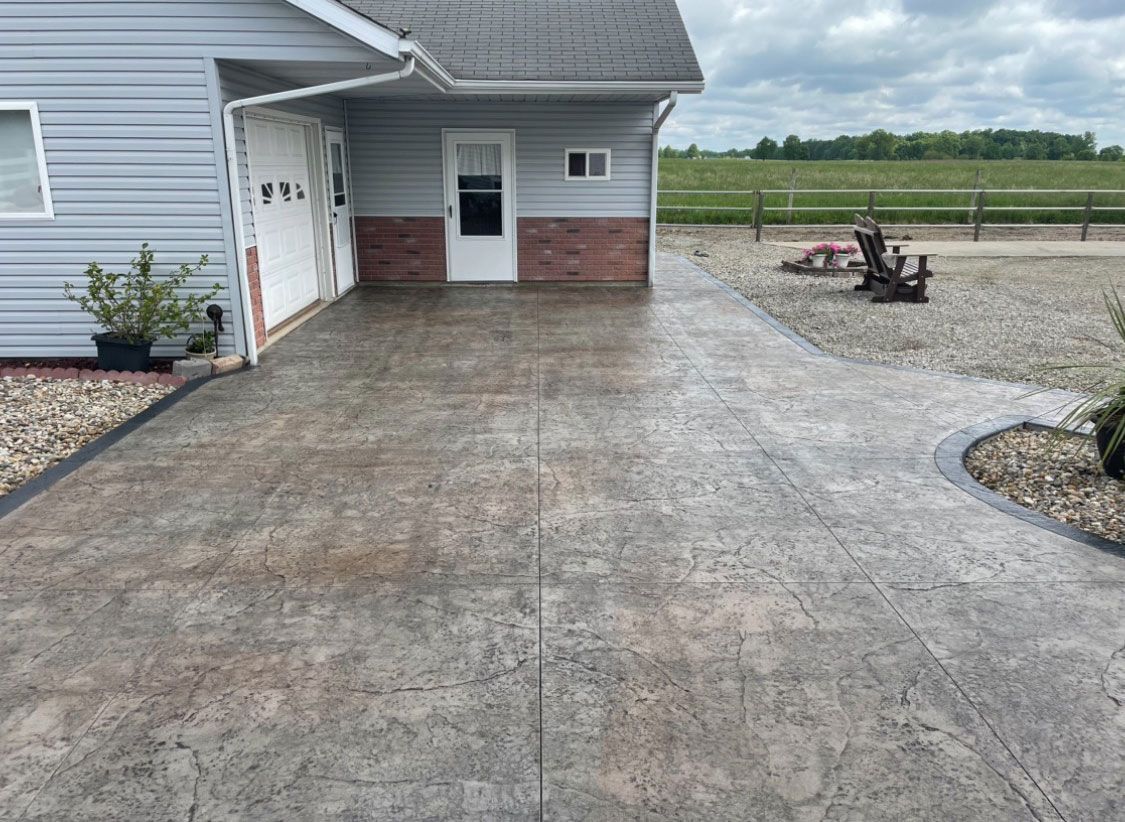 A nice concrete driveway leads to a house with a garage