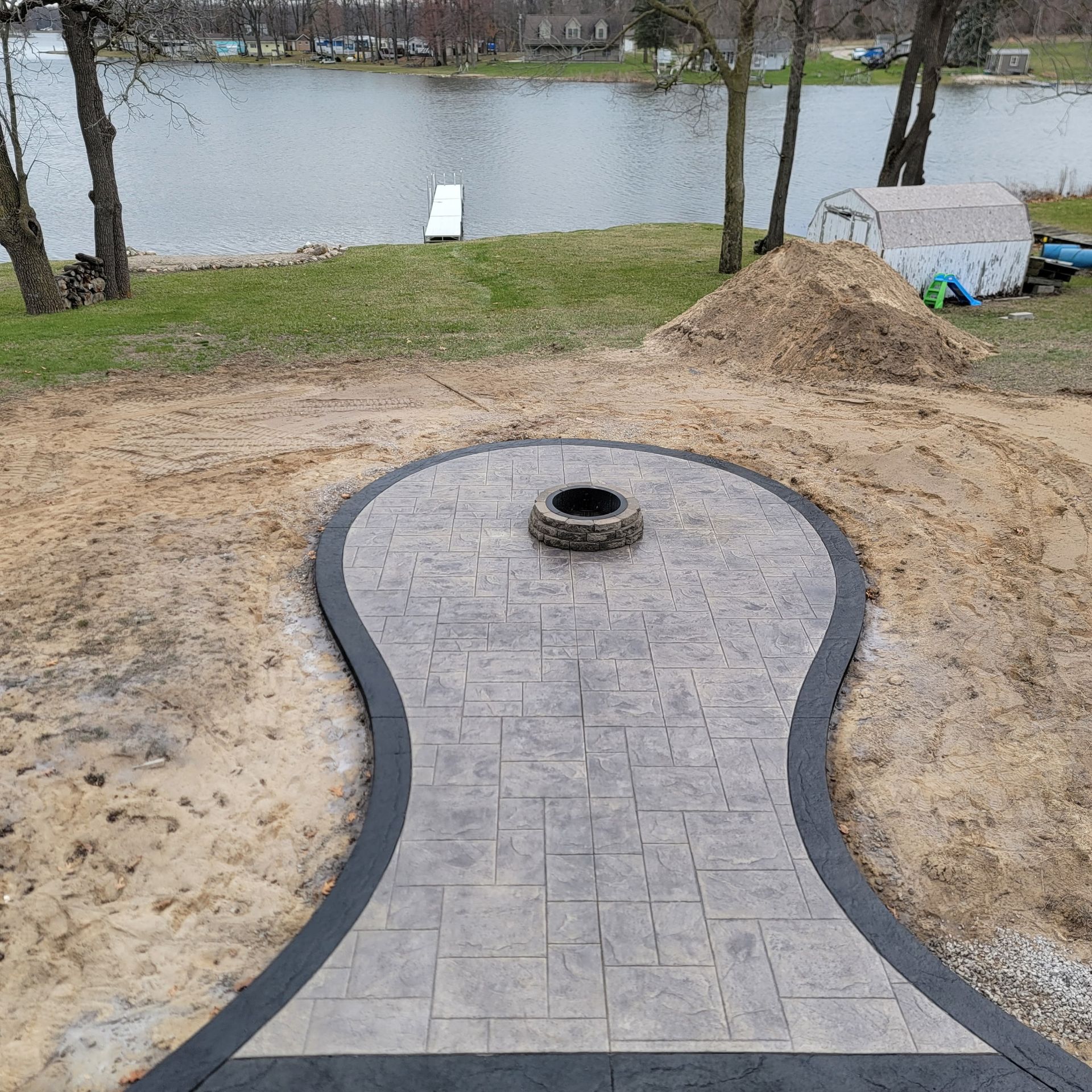 A concrete walkway with a fire pit in the middle