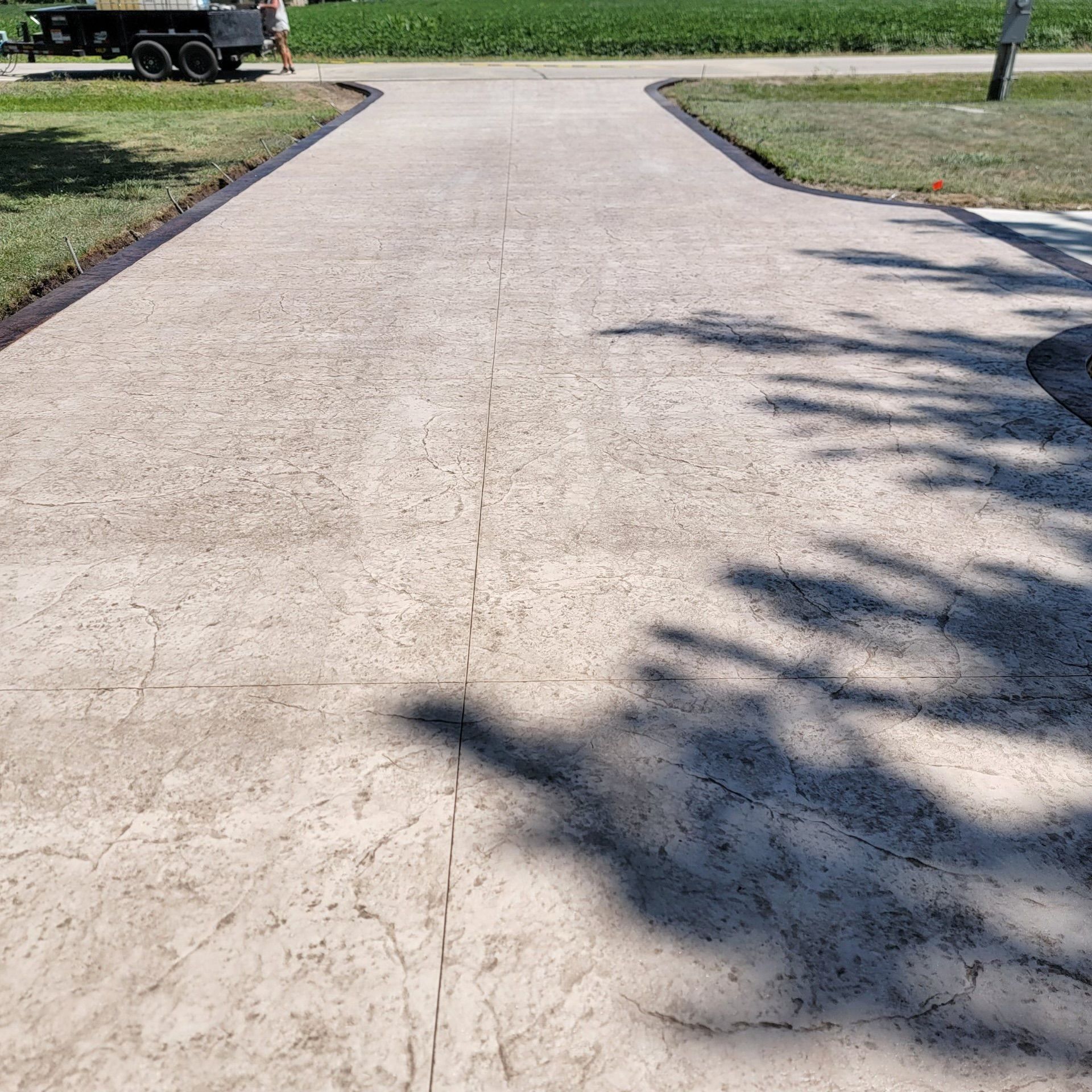A concrete driveway with a truck parked on the side of it