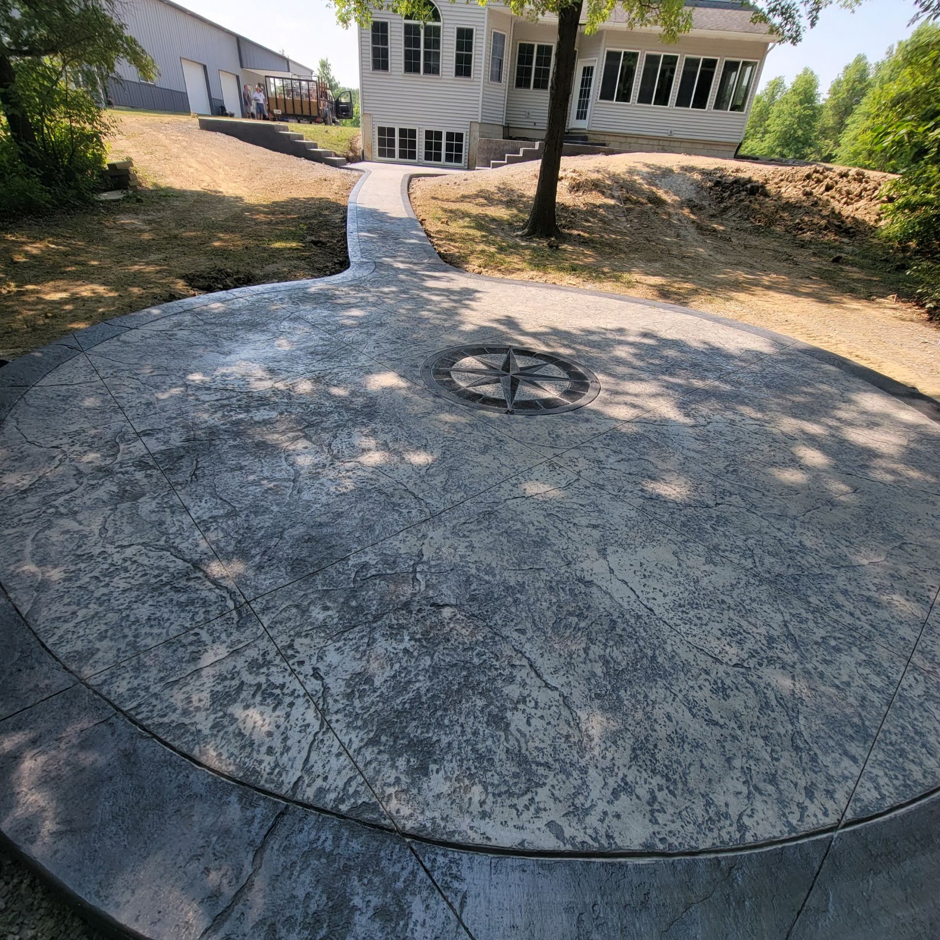 A circular concrete patio with a compass on it