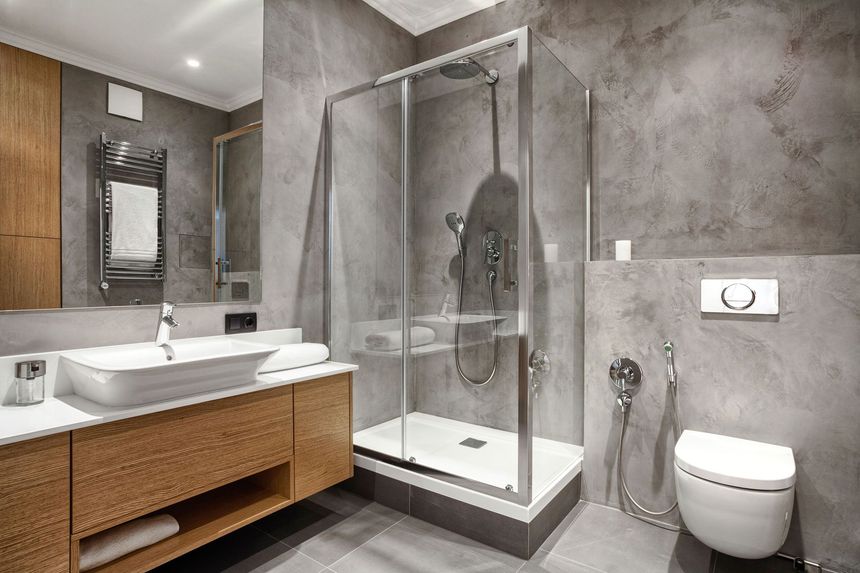 A bathroom with a walk in shower , sink , toilet and mirror