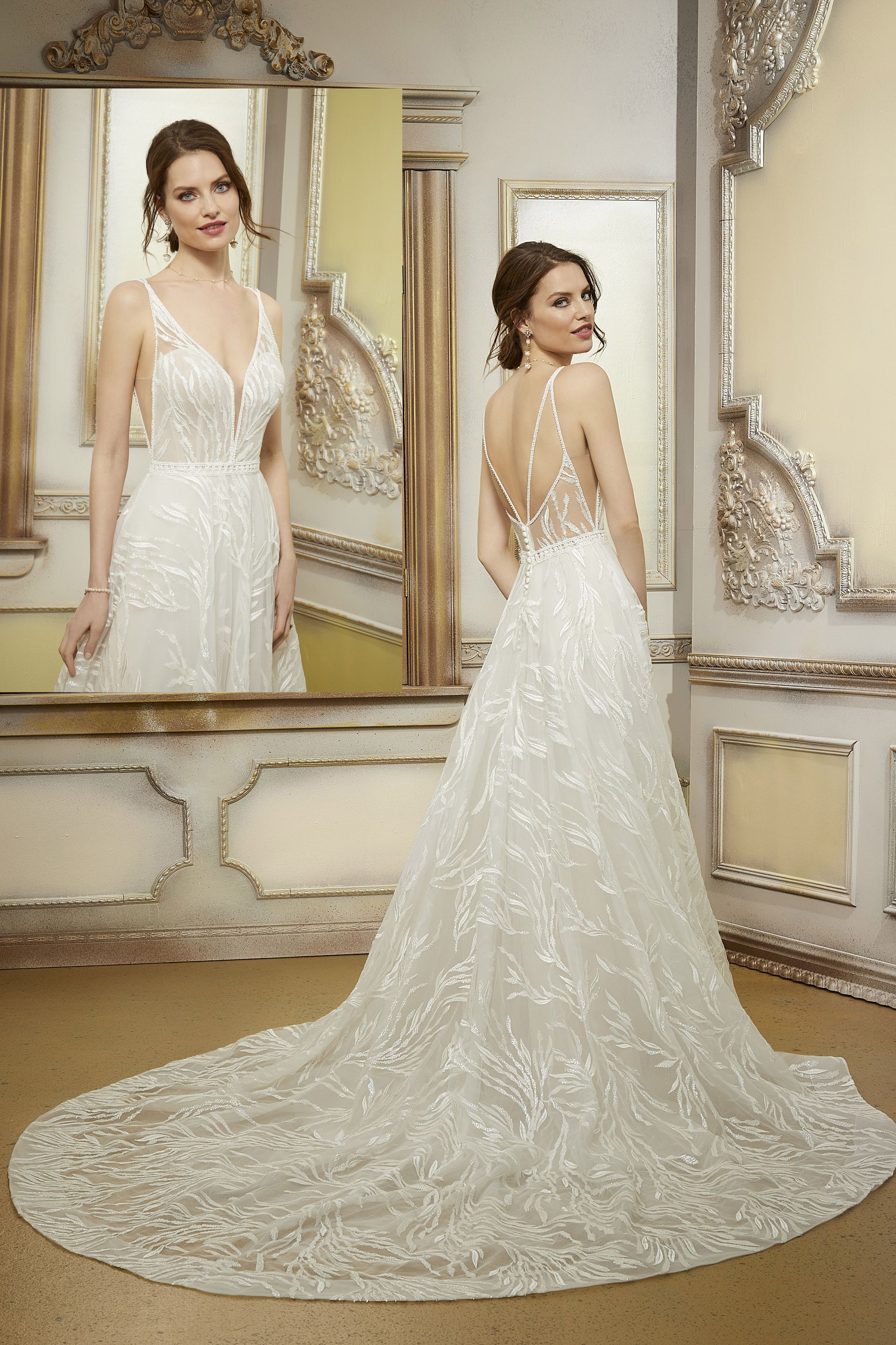 Una donna in abito da sposa è in piedi davanti allo specchio.