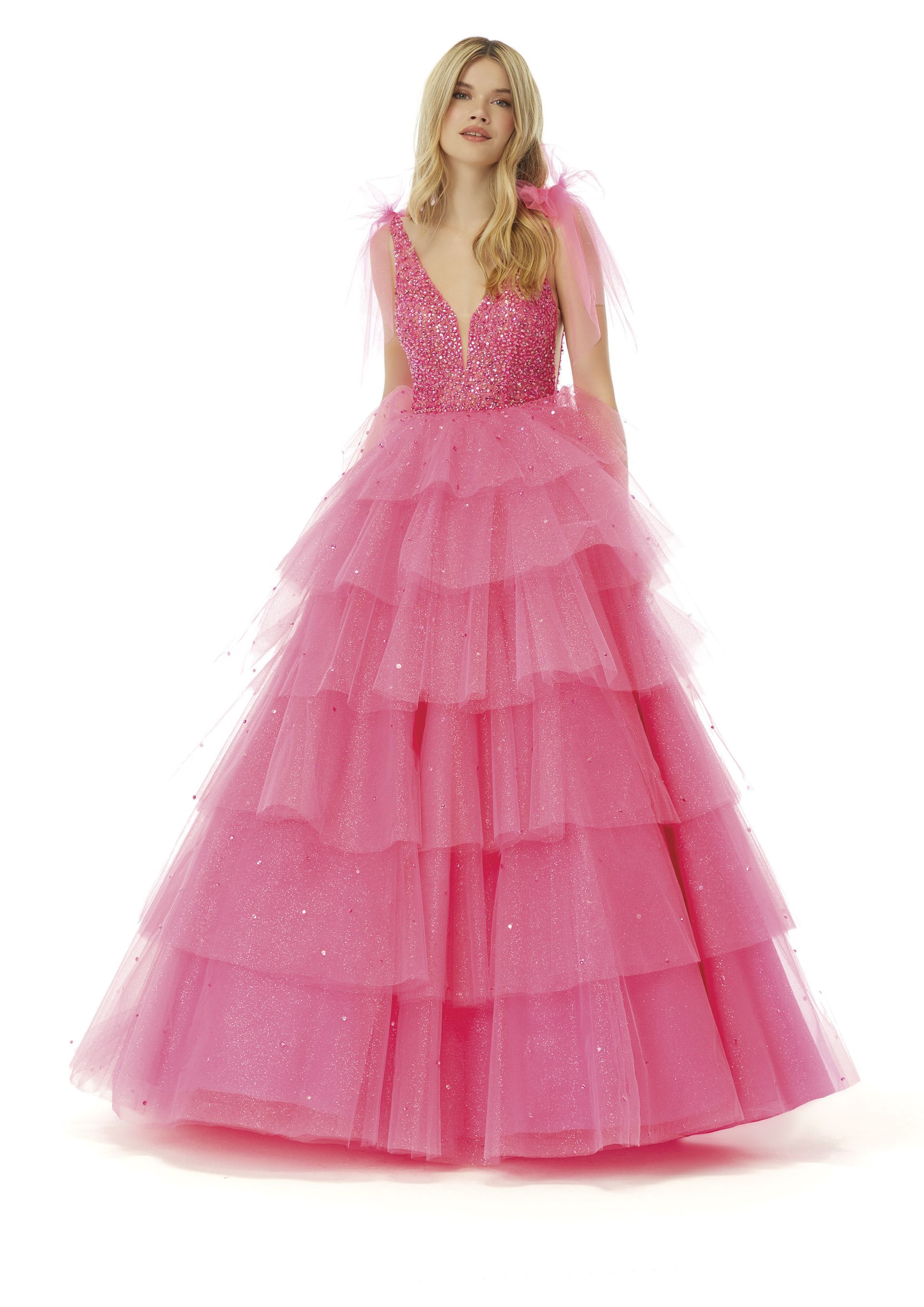 Una donna indossa un abito da ballo rosa con volant.