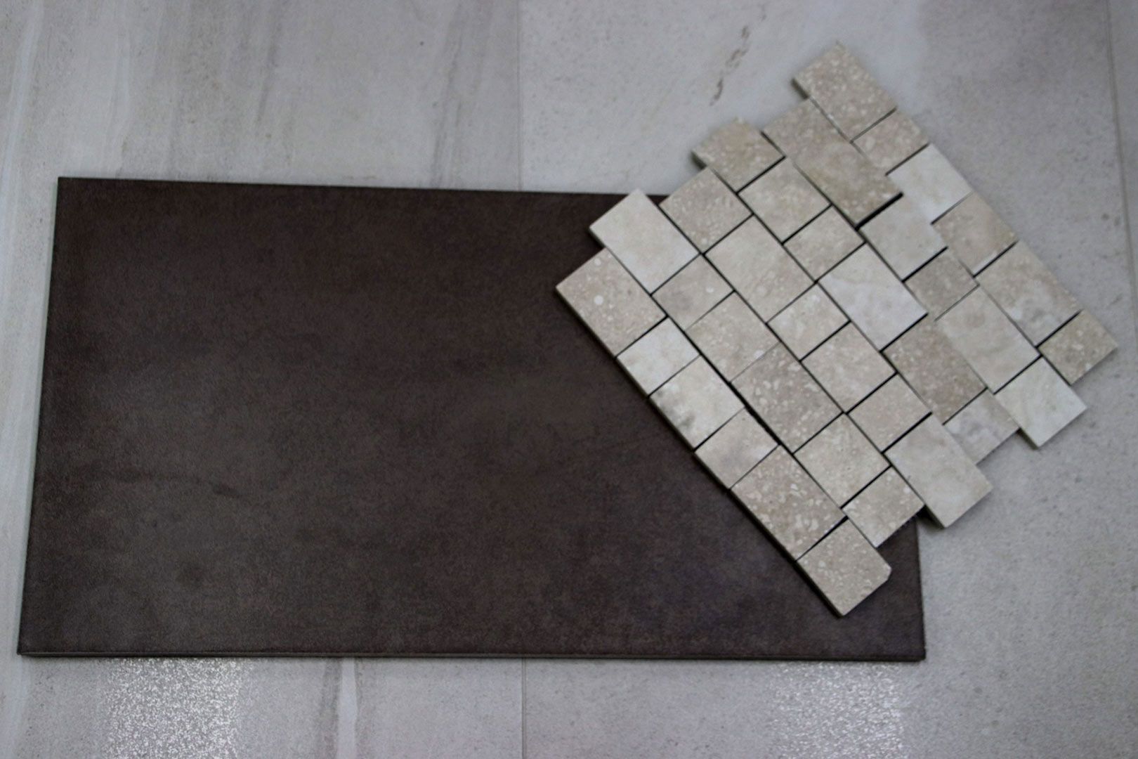 A Piece of Tile Is Laying on Top of Another Piece of Tile — Traditional Tiles & Flooring In Woree, QLD
