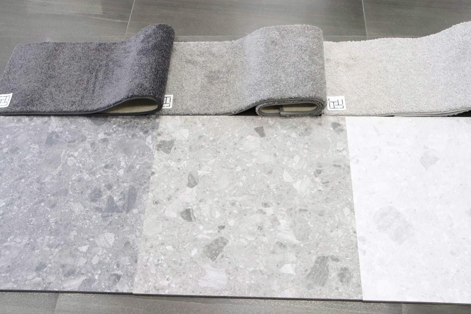 Three Rolls of Carpet Are Sitting on Top of Each Other on A Tiled Floor — Traditional Tiles & Flooring In Woree, QLD