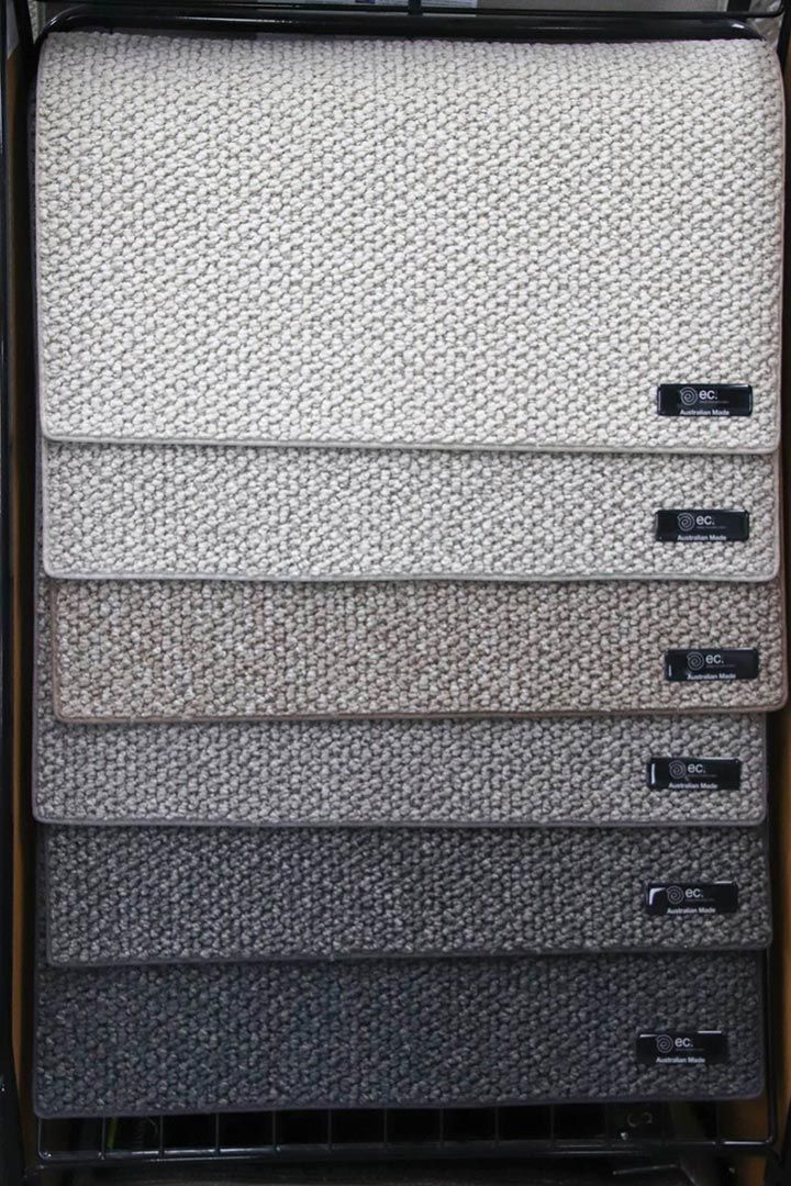 A Bunch of Carpets Are Stacked on Top of Each Other on A Shelf — Traditional Tiles & Flooring In Woree, QLD
