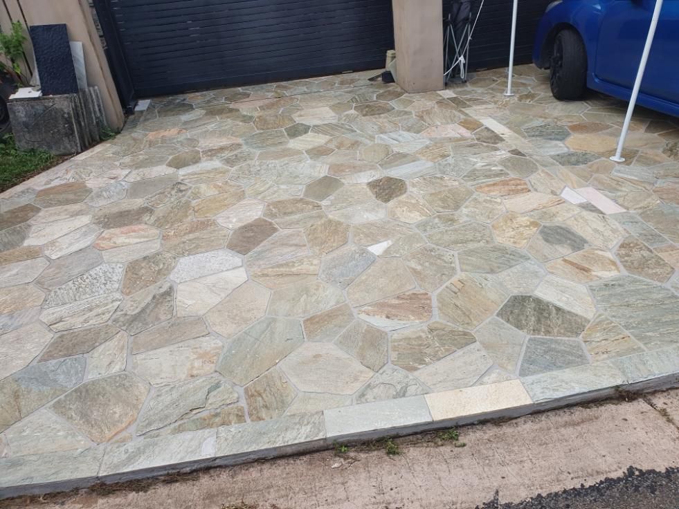 A Blue Car is Parked in a Driveway With a Tiled Floor — Traditional Tiles & Flooring in Palm Cove, QLD