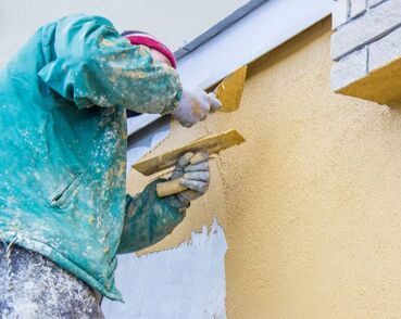 worker doing exterior stucco repair