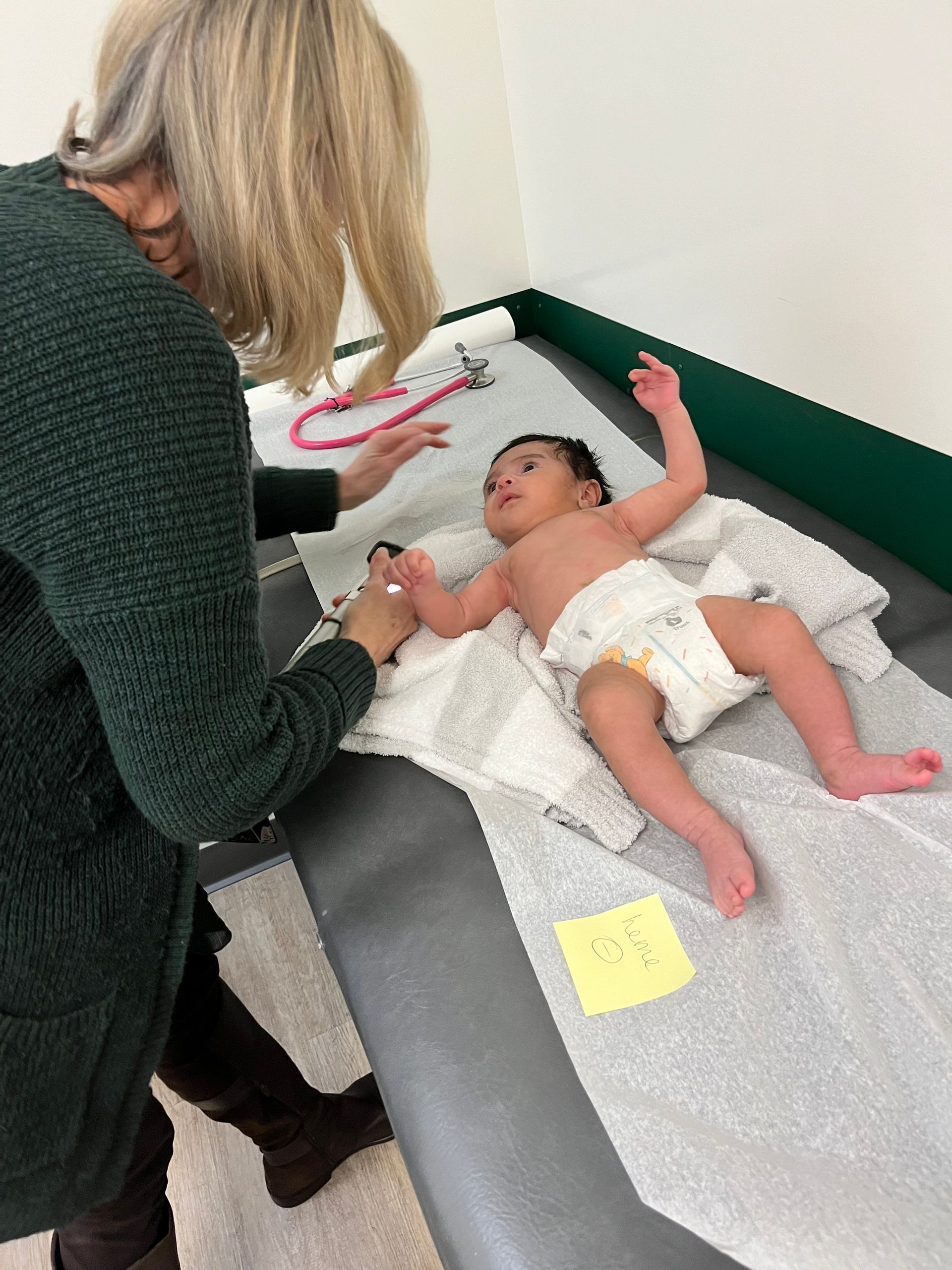 A baby in a diaper is being examined by a doctor