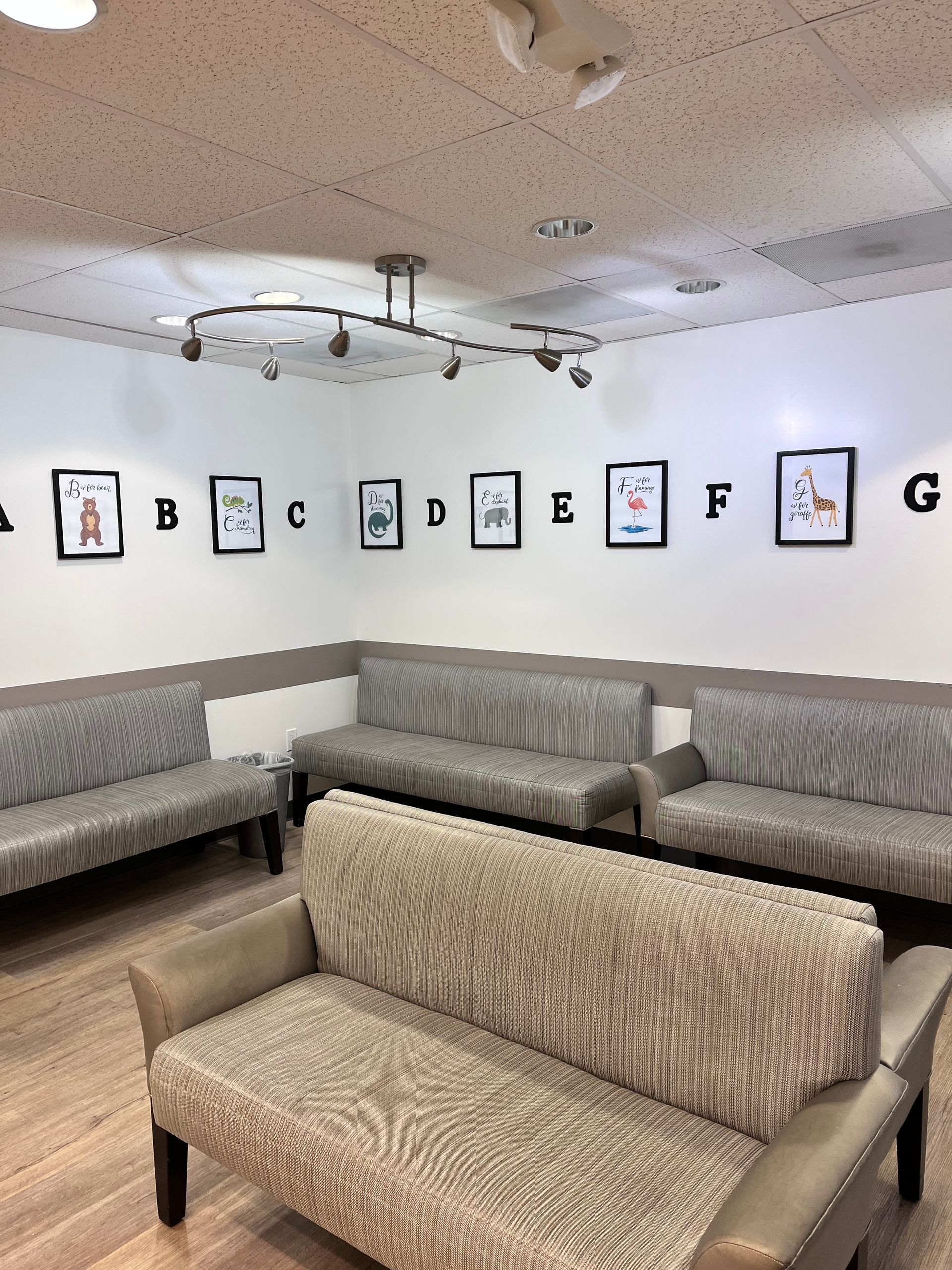 A waiting room with a couch and a few pictures on the wall
