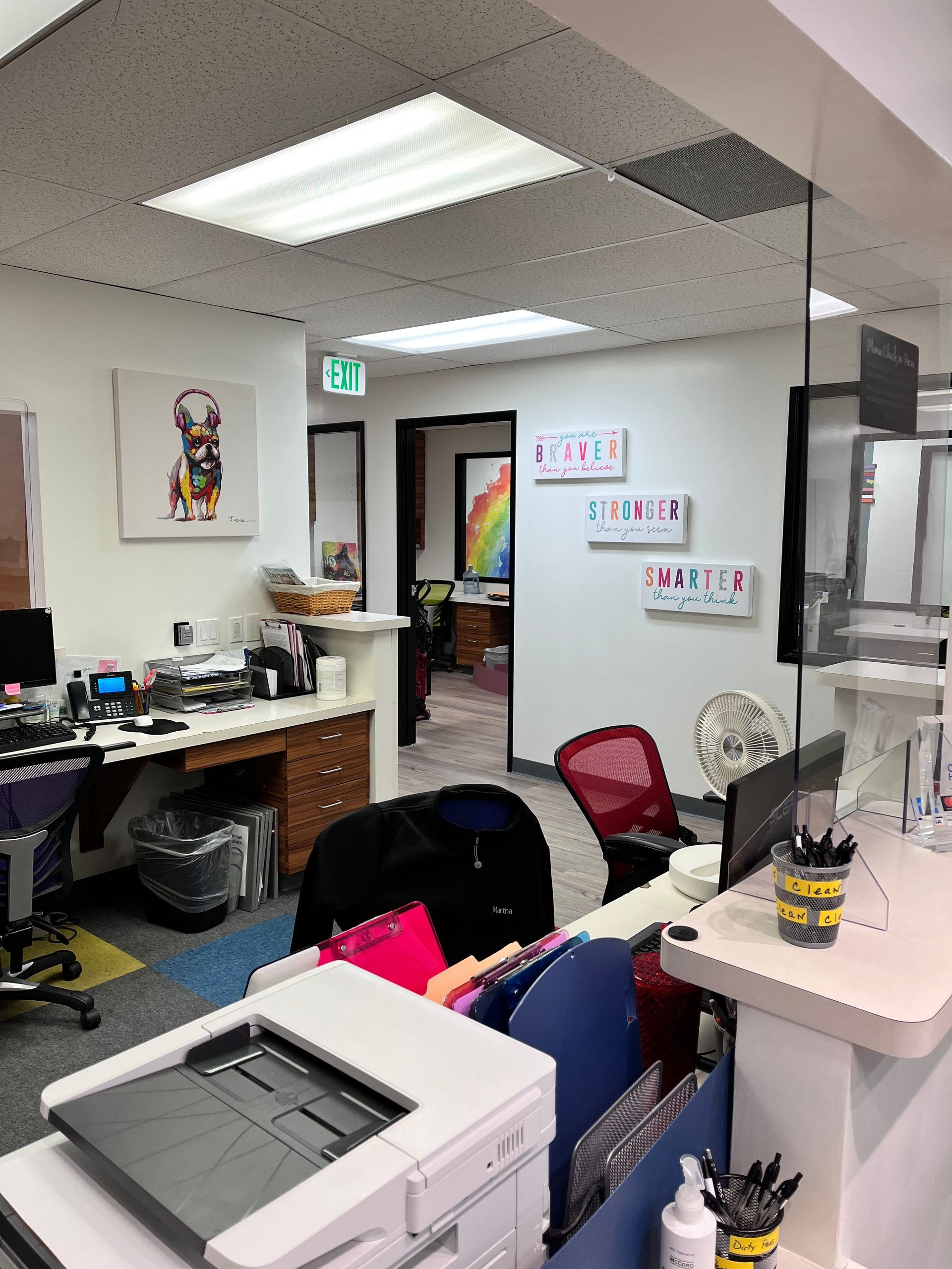 An office with a printer and a picture of a dog on the wall