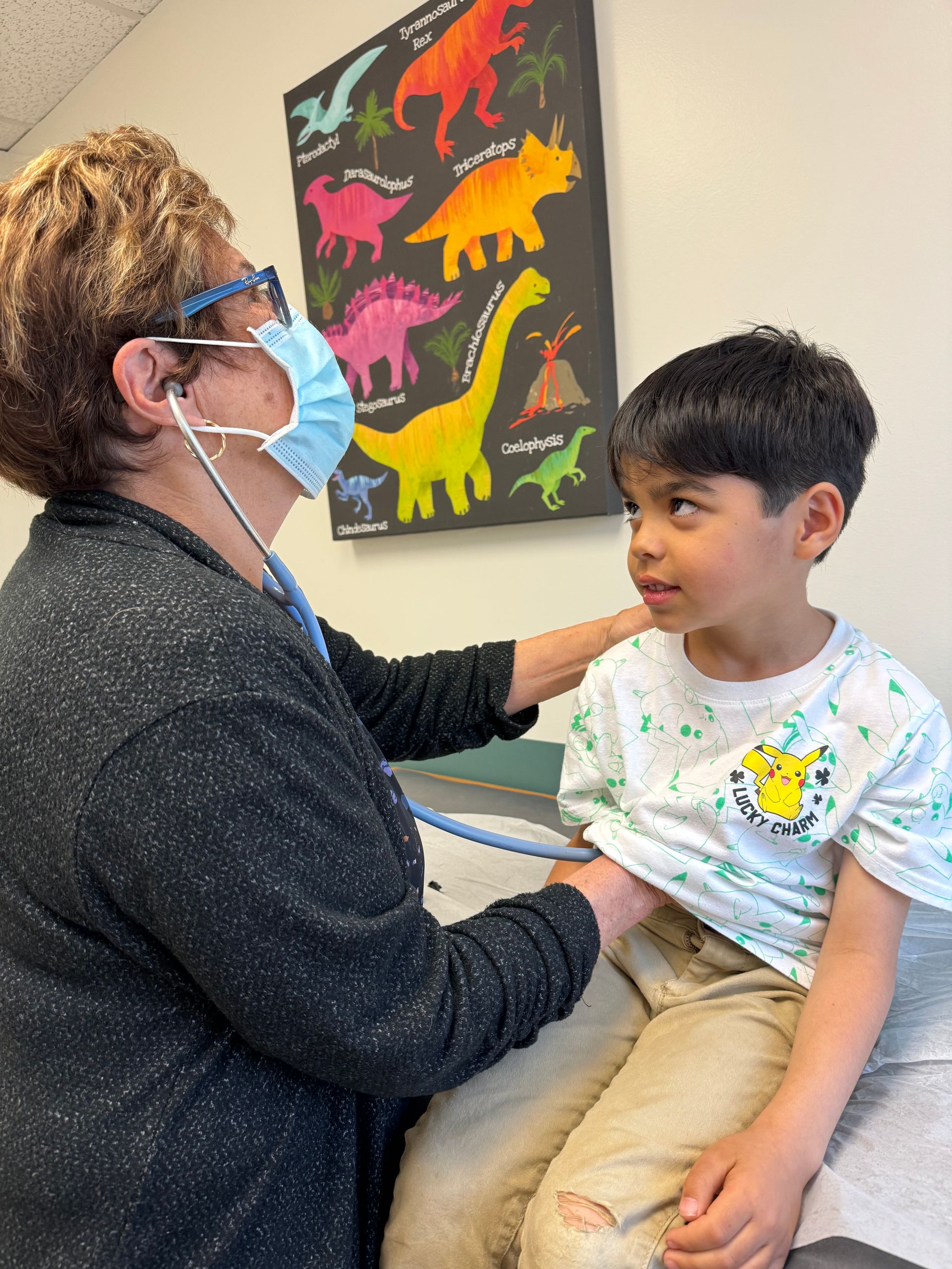 A doctor is examining a young boy with a stethoscope.