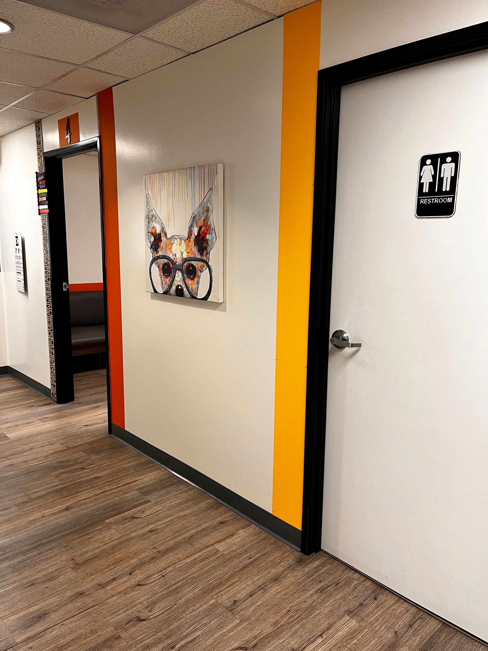 A hallway with two doors and a painting on the wall.