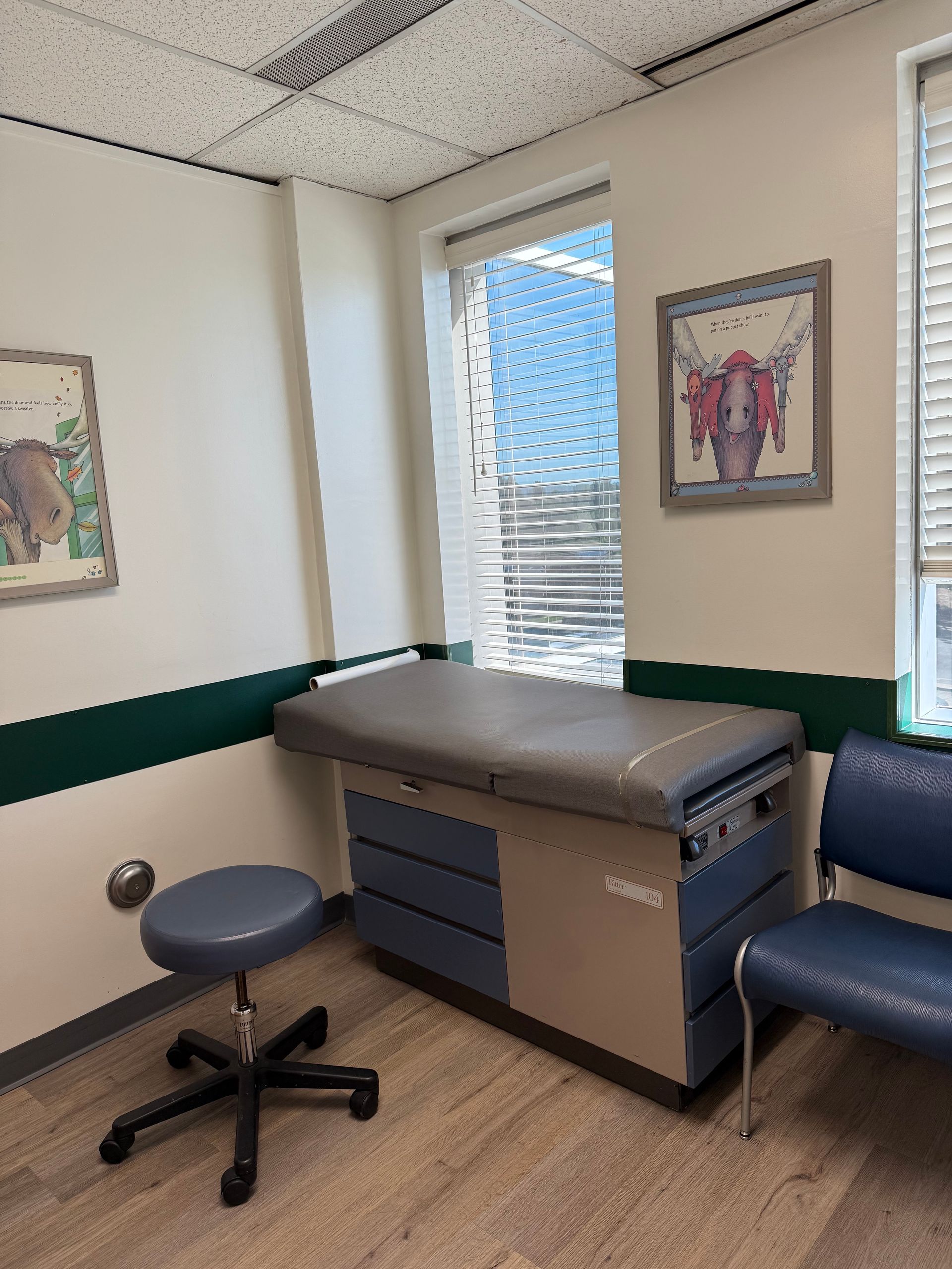 A doctor 's office with a table and chairs