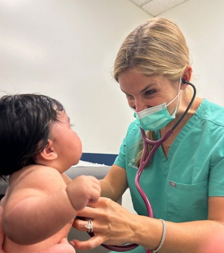 A nurse is listening to a baby 's heartbeat with a stethoscope