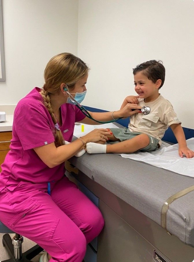 A nurse is examining a young boy with a stethoscope.