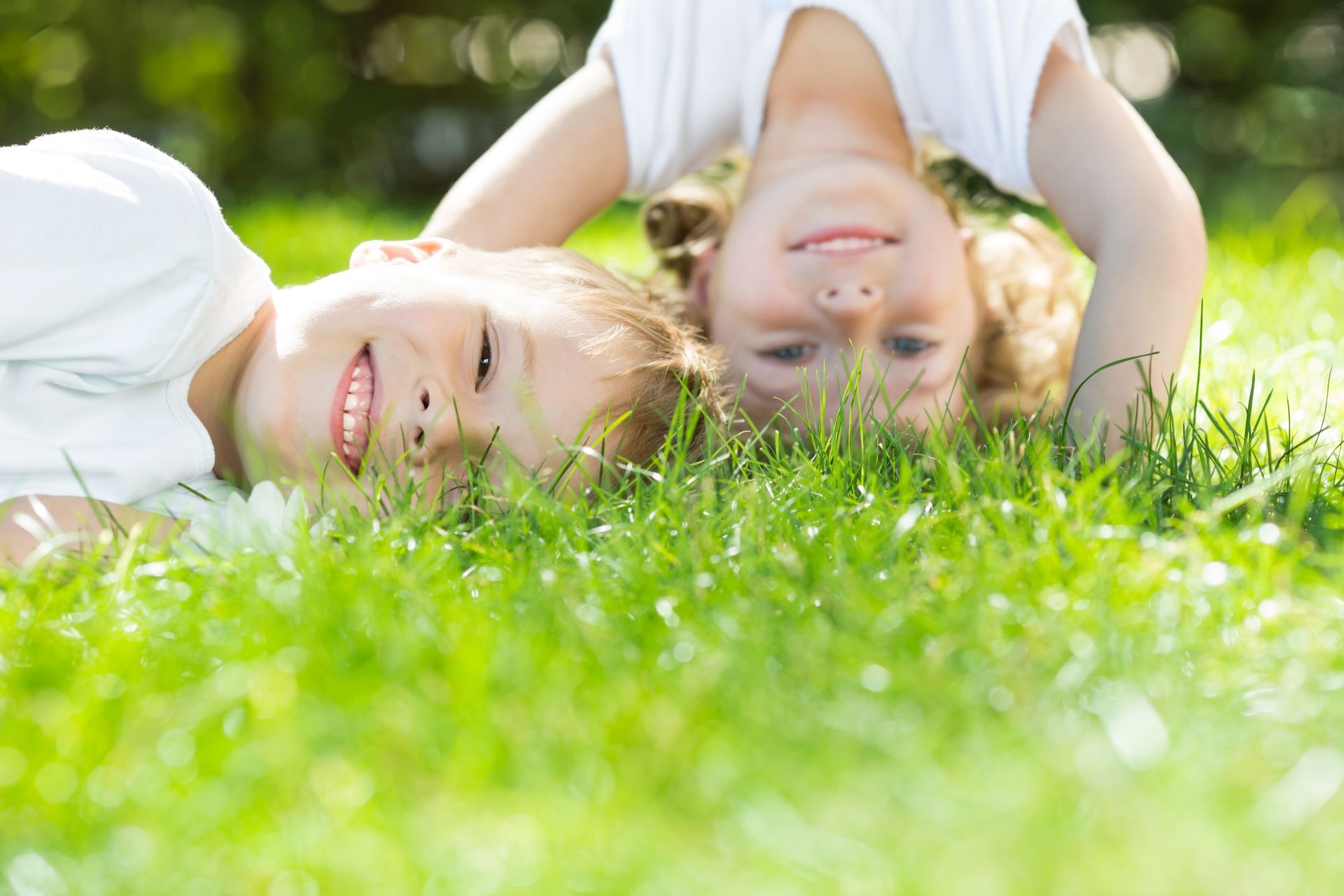 A boy and girl are playing in the grass