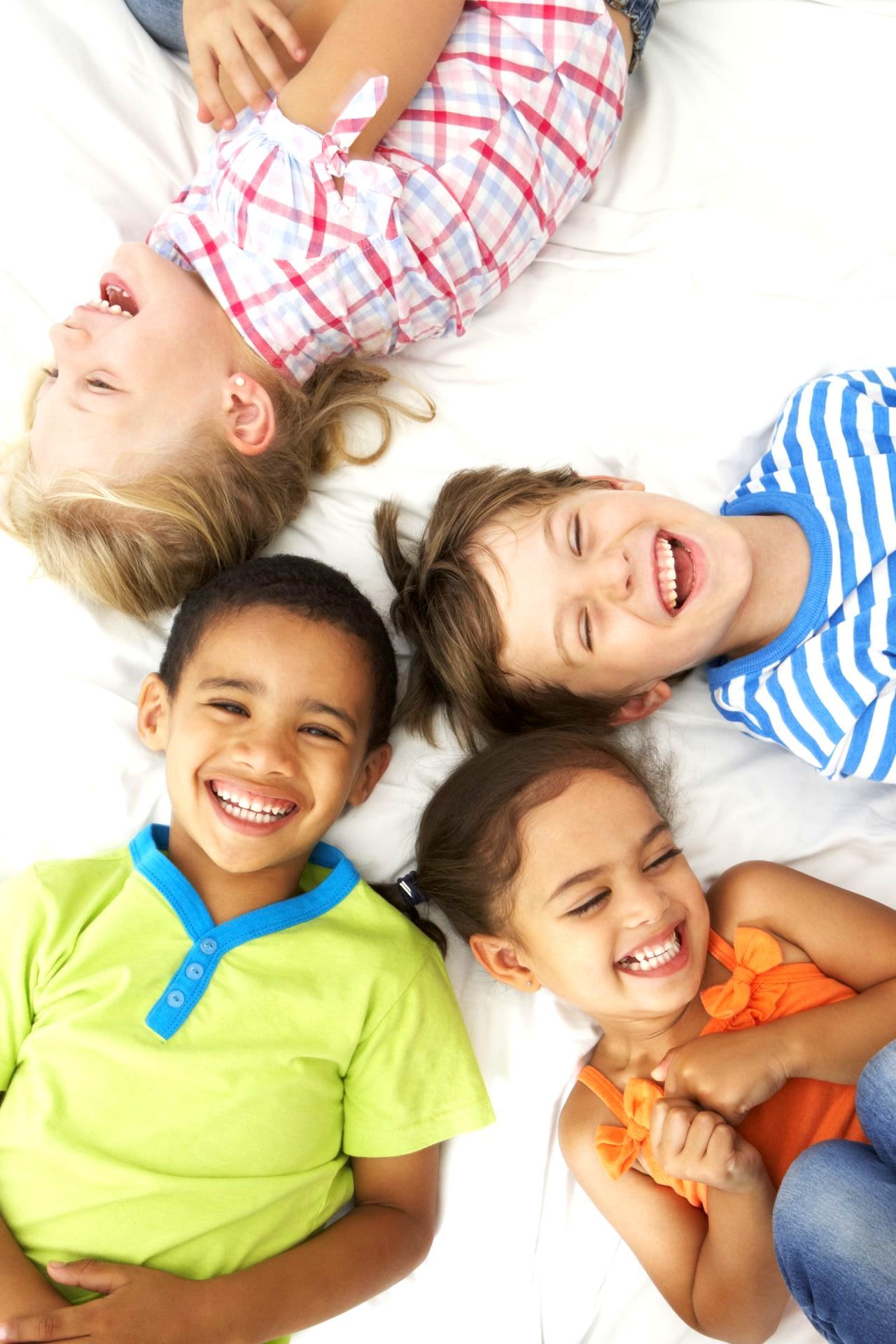 A group of smiling, laughing children are in a circle