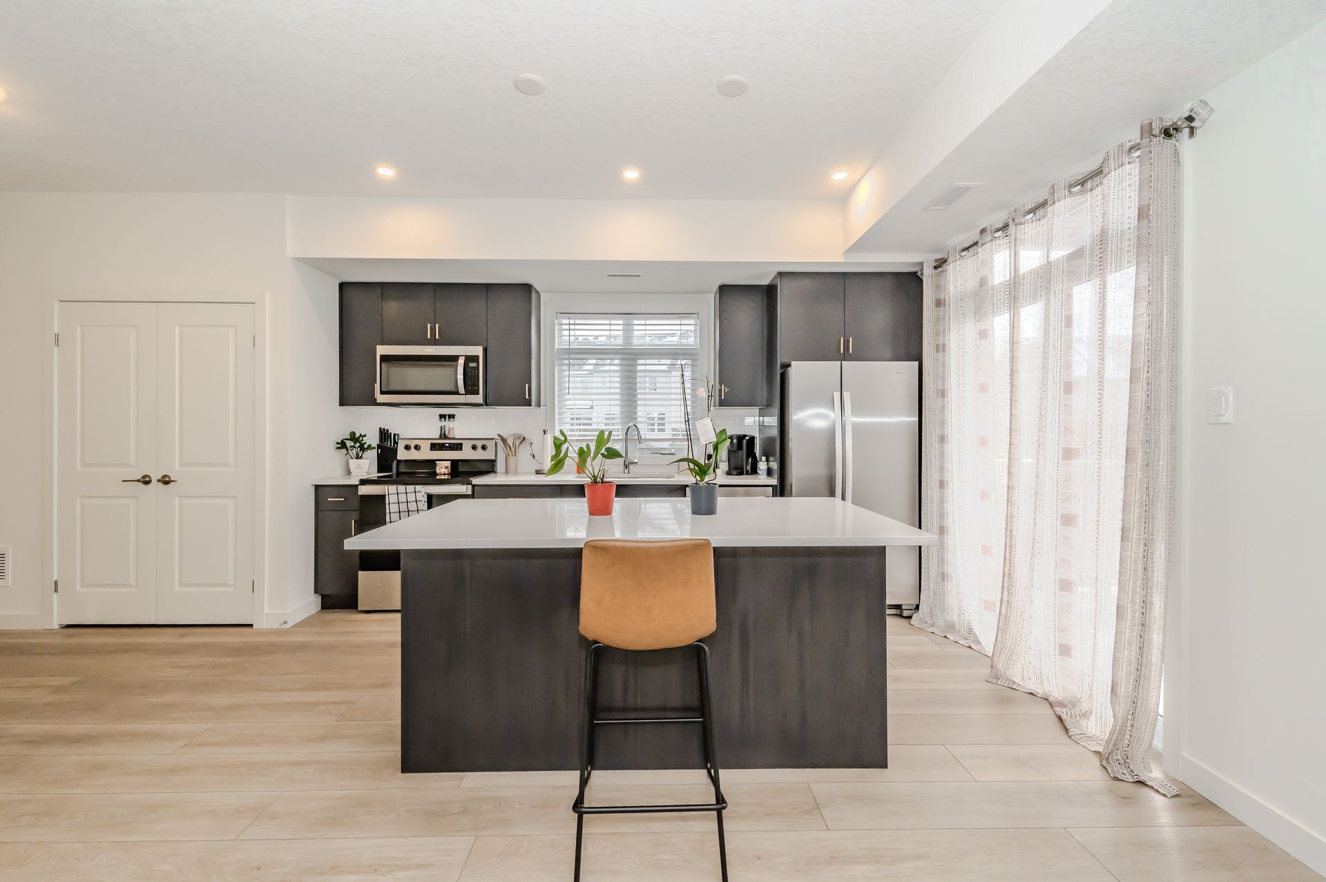 A kitchen with a large island and stainless steel appliances.