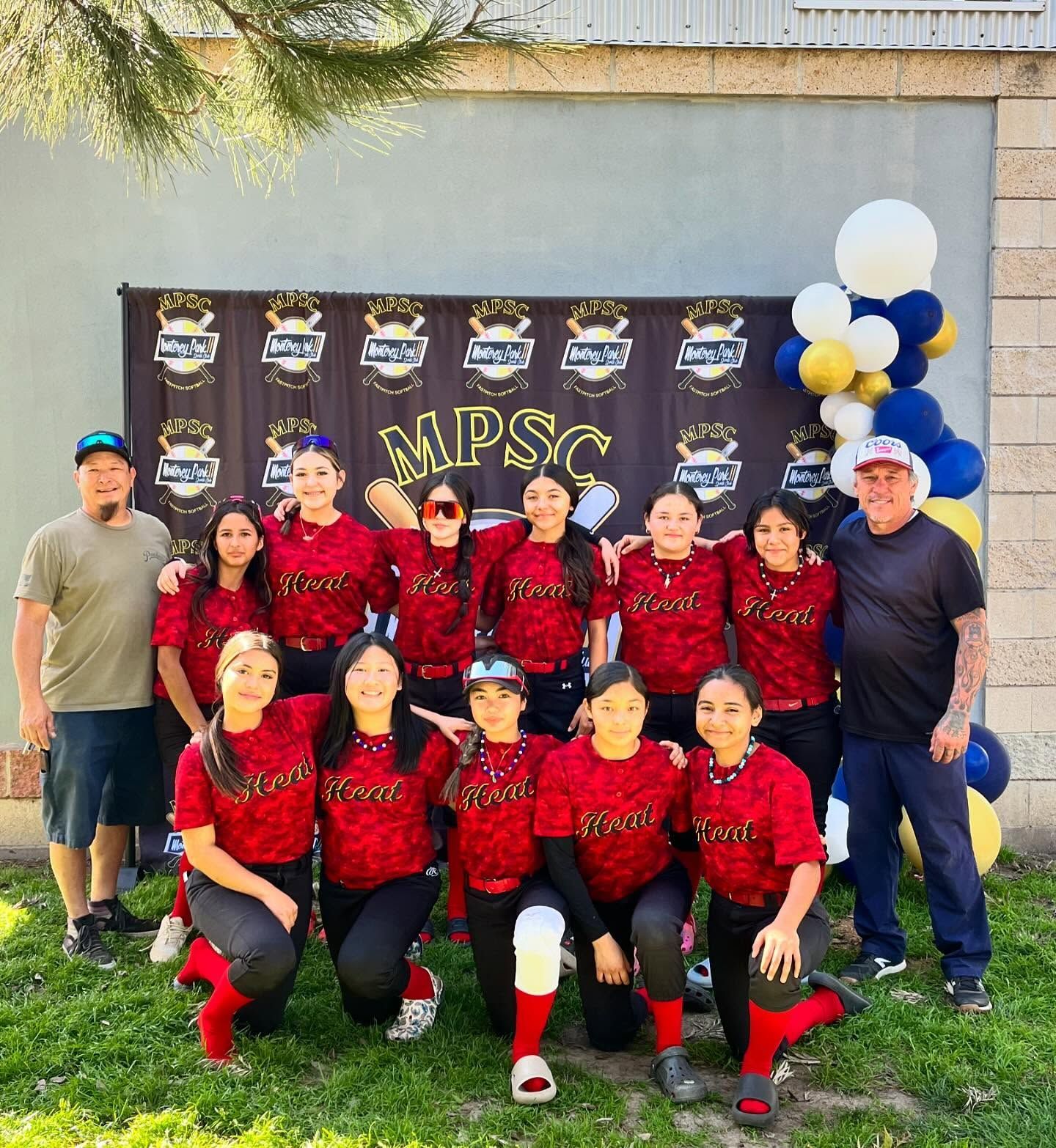 Baseball glove with ball on green grass, with blurred baseballs in the background.