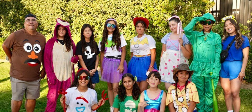 Baseball player sliding into home plate, catcher in front. Blue and gold uniforms, action shot.