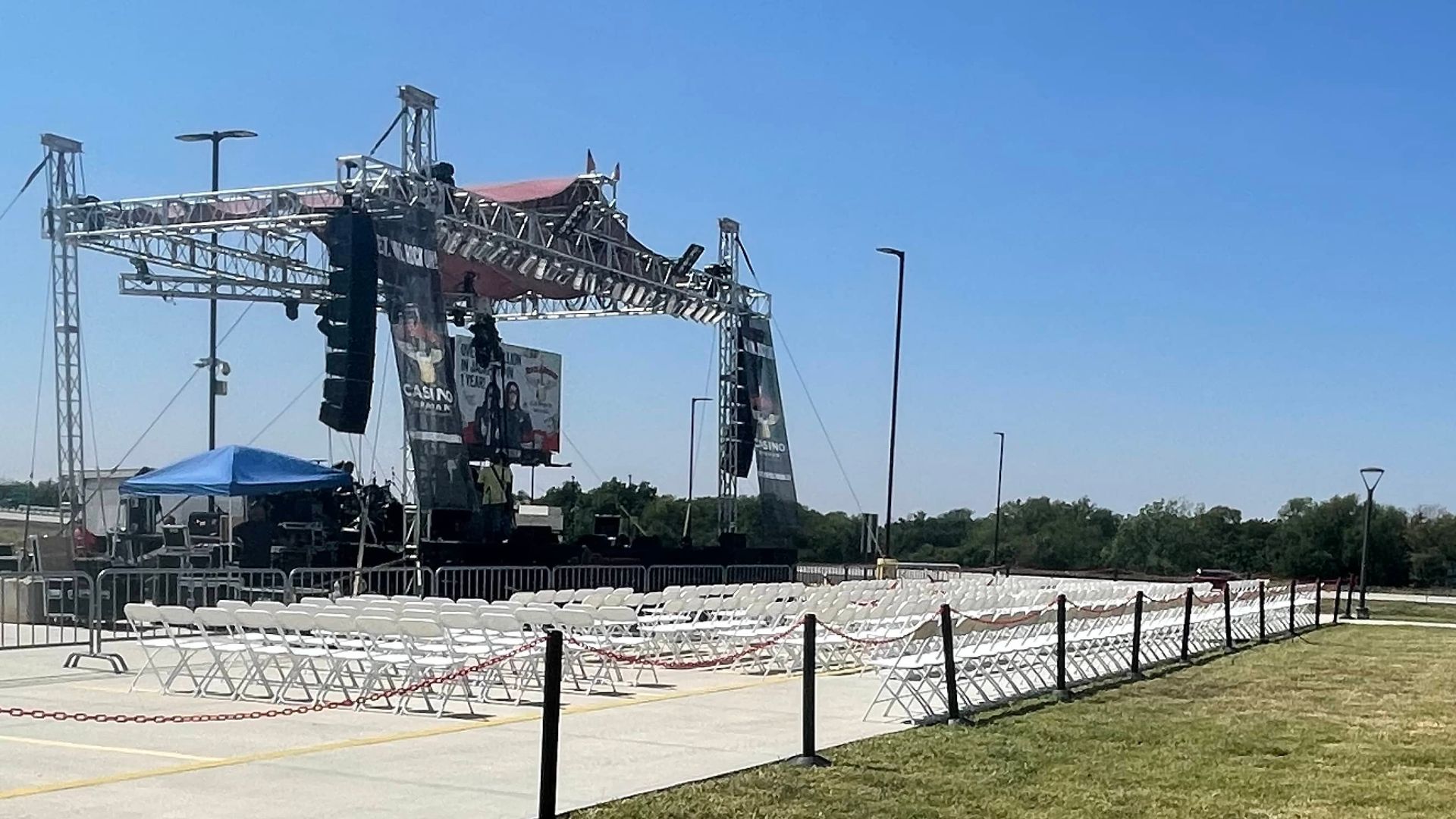 a large stage with hundreds of white chairs in front of it.