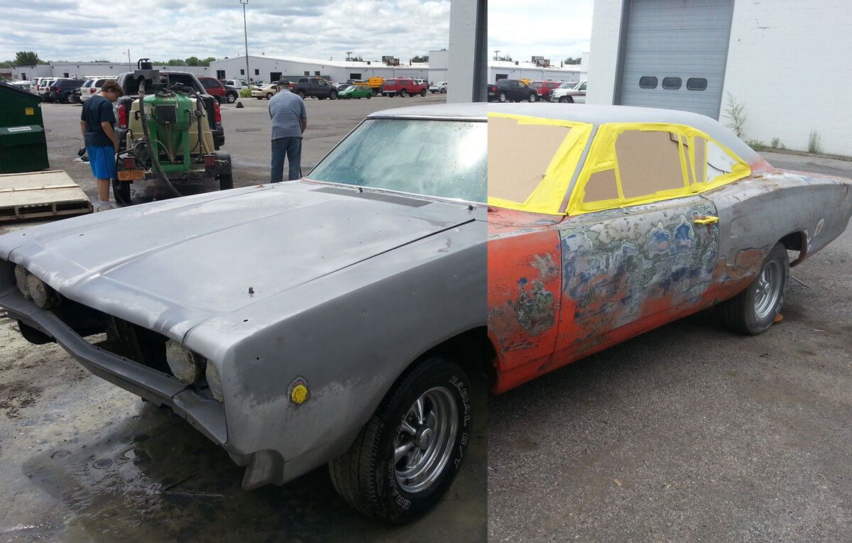 A dodge charger is being painted in a parking lot