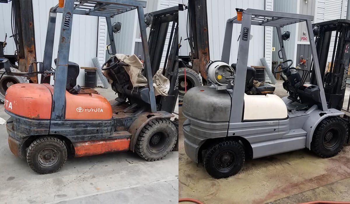 Two forklifts are parked next to each other in a parking lot.