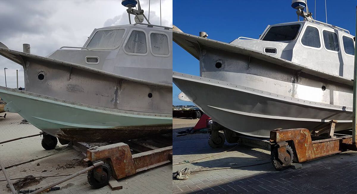 A boat is sitting on a trailer next to another boat.