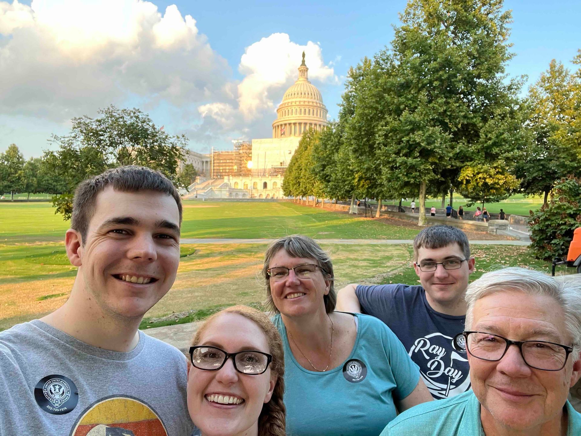A group of people are posing for a picture in front of the capitol building.