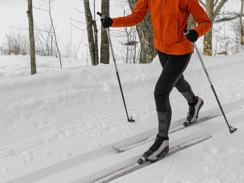 A person is cross-country skiing on a snowy trail.