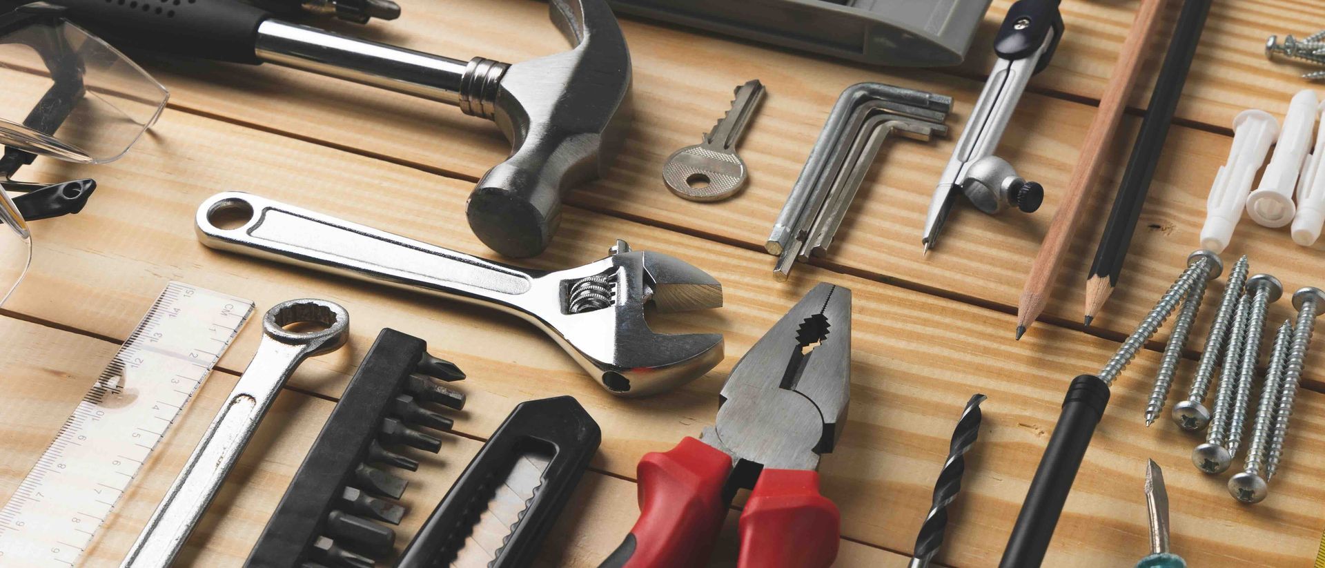 A bunch of tools are laying on a wooden table