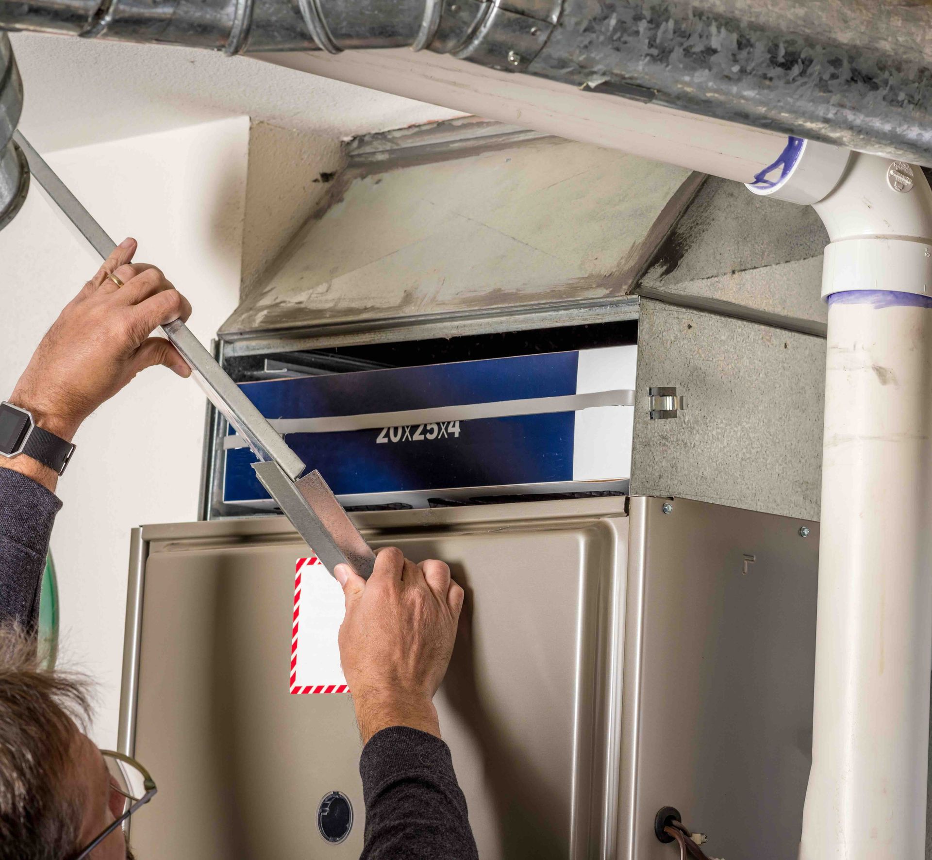 A man is working on a furnace in a basement