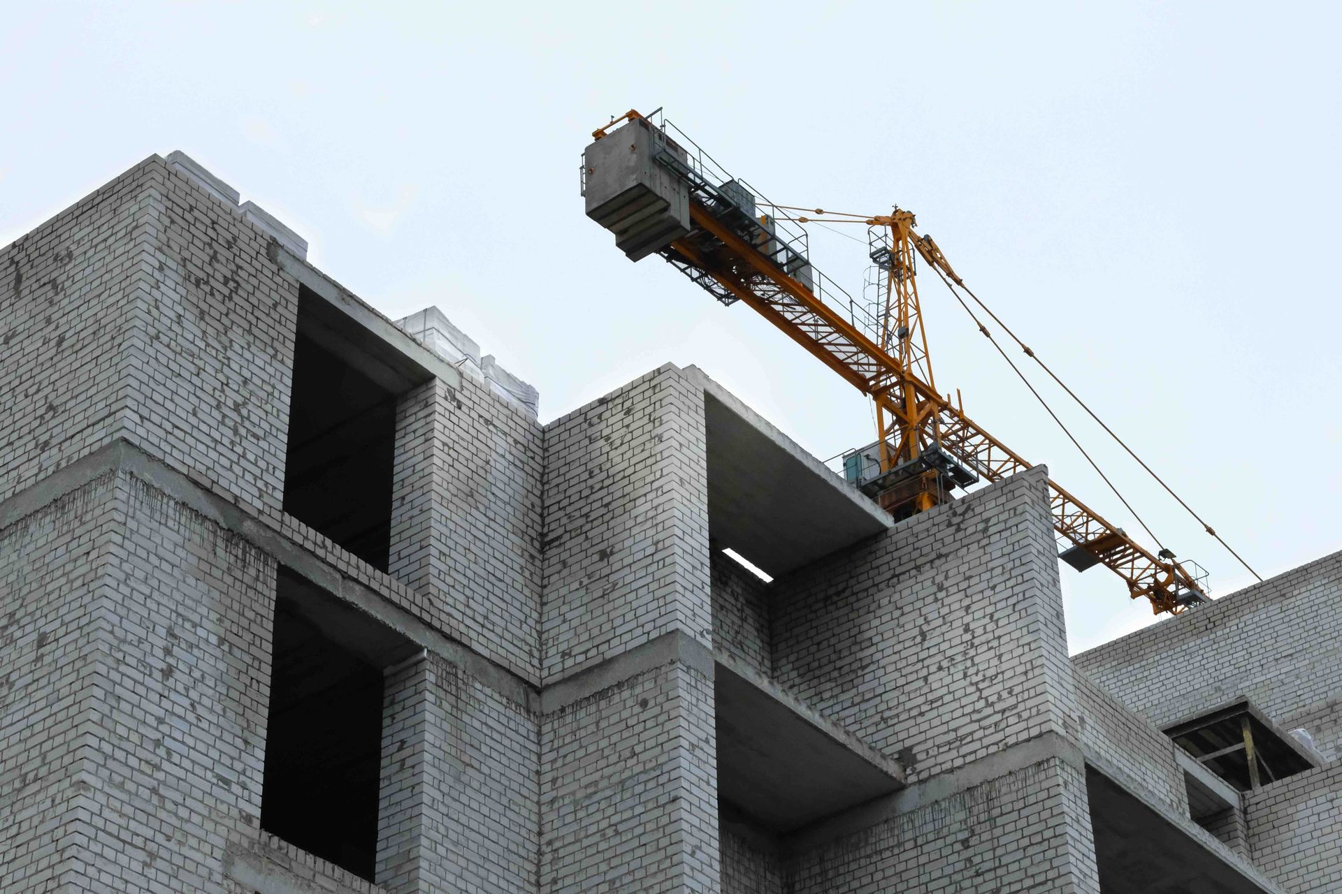 A crane is sitting on top of a building under construction.