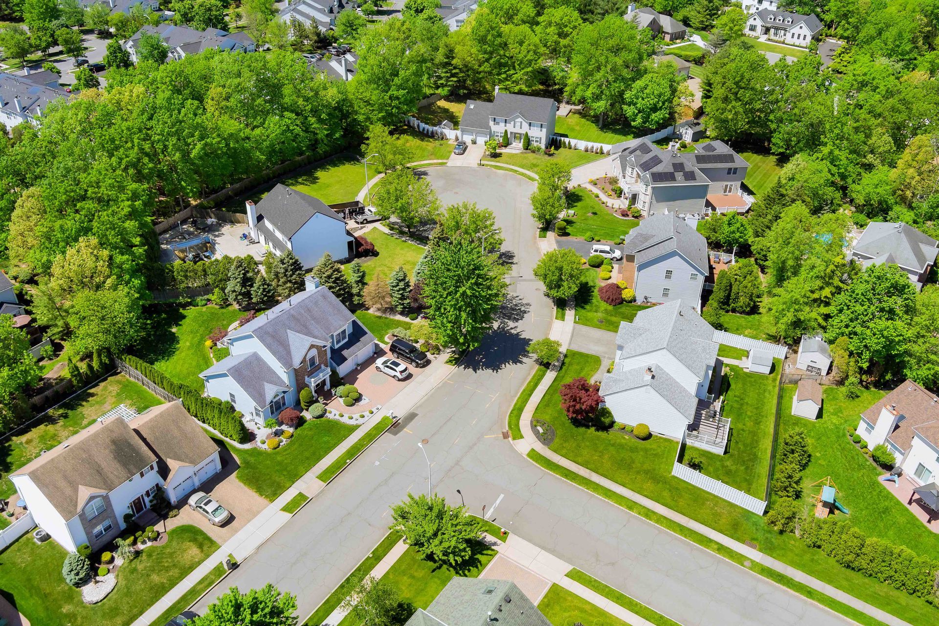 An aerial view of a residential neighborhood with lots of houses and trees