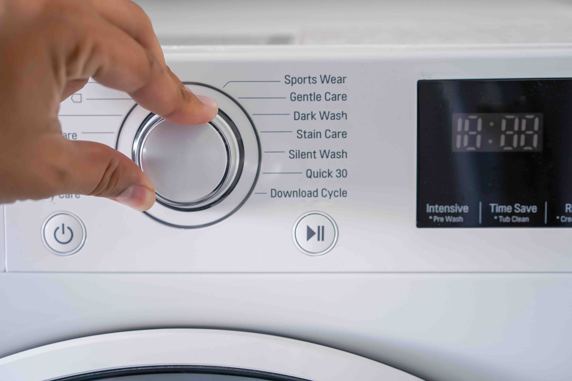 A person is pressing a button on a washing machine.