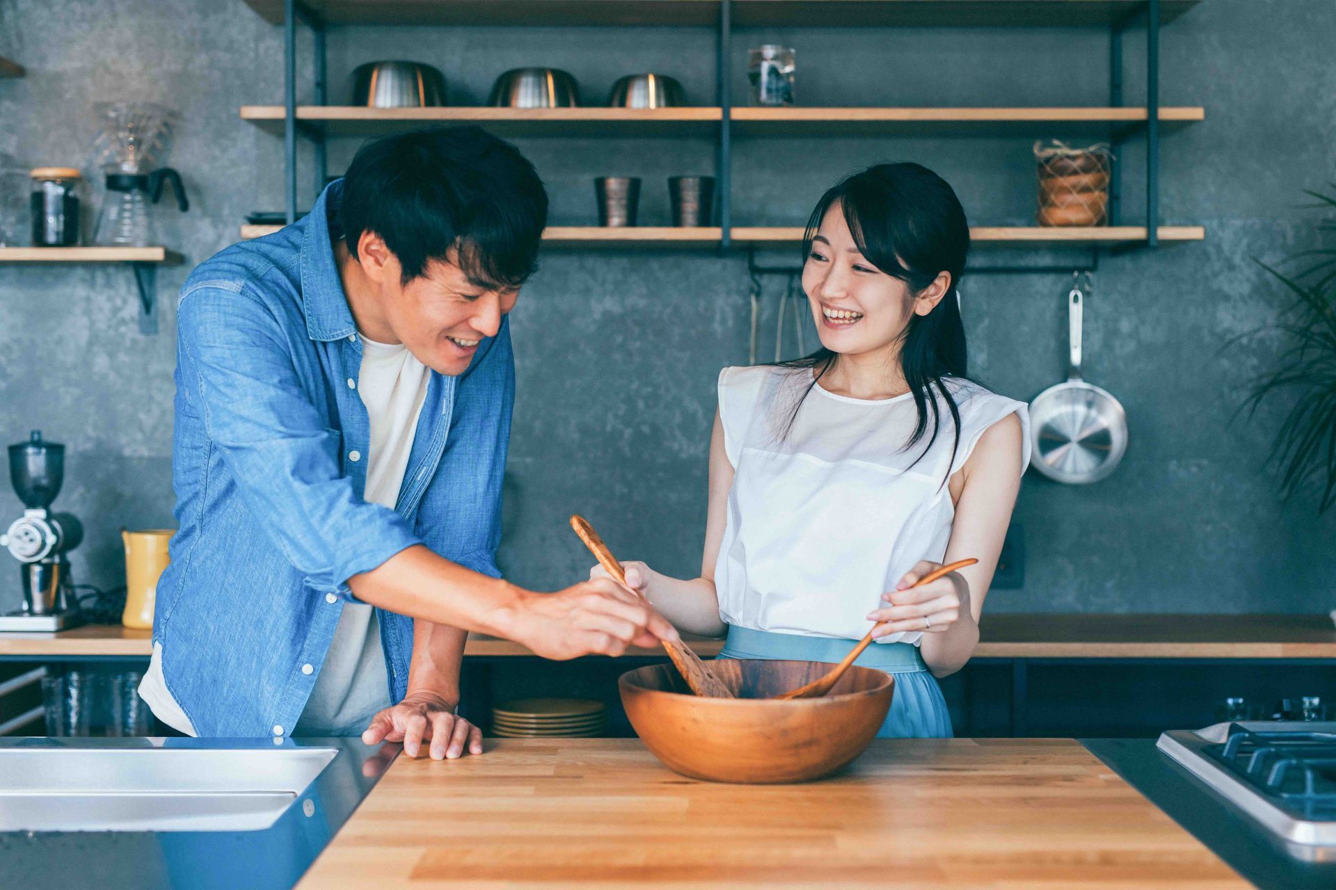 A man and a woman are cooking together in a kitchen.