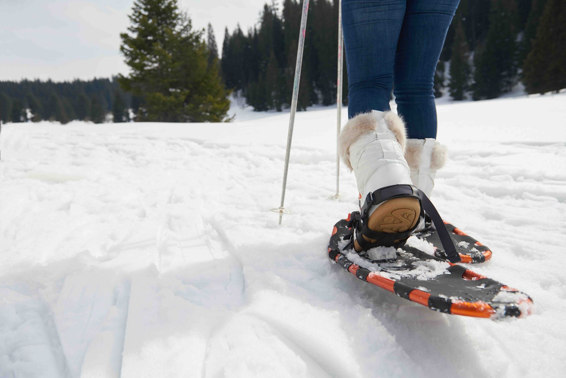 A person is snowshoeing down a snowy hill.