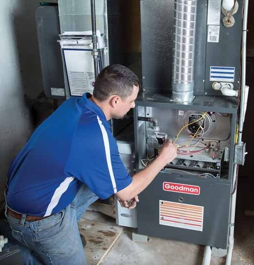 technician looking inside wiring of furnace