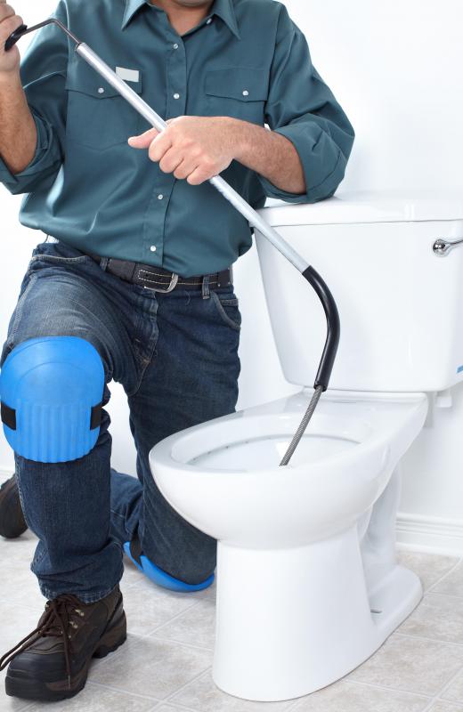 plumber using tool to unclog sink drain