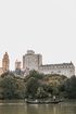 A couple is riding a gondola on a lake in central park.
